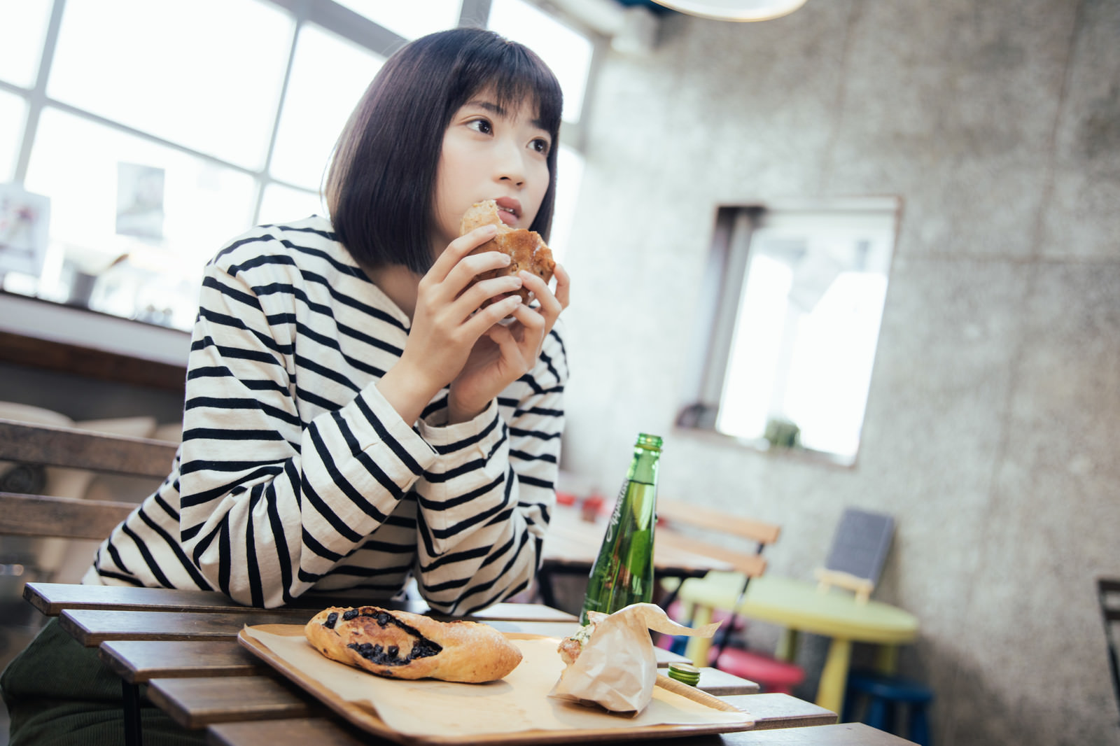 フードコートでおやつに菓子パンを食べる女性の写真素材 - ぱくたそ