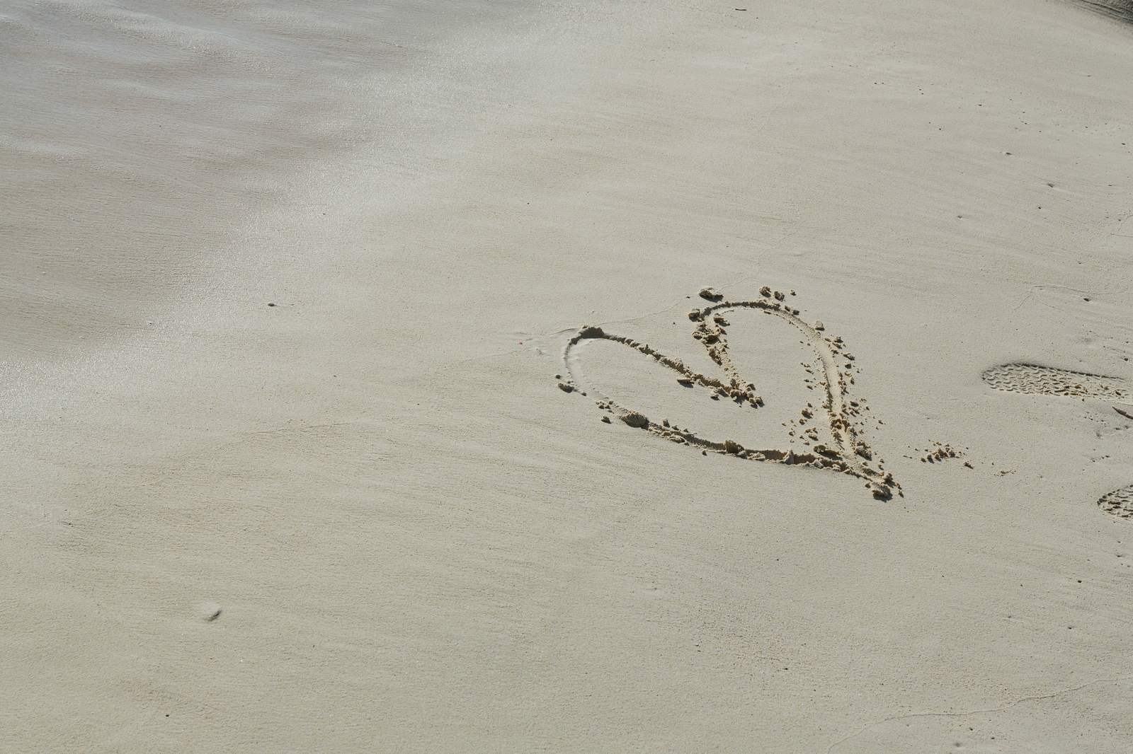 「宮古島の砂浜に書いたハート | フリー素材のぱくたそ」の写真