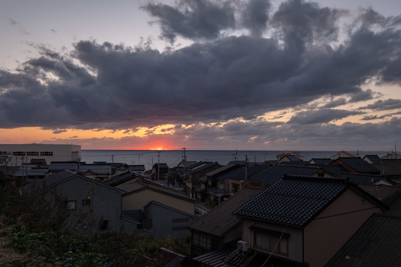 沈む夕日と海沿いの民家の写真 画像 を無料ダウンロード フリー素材のぱくたそ