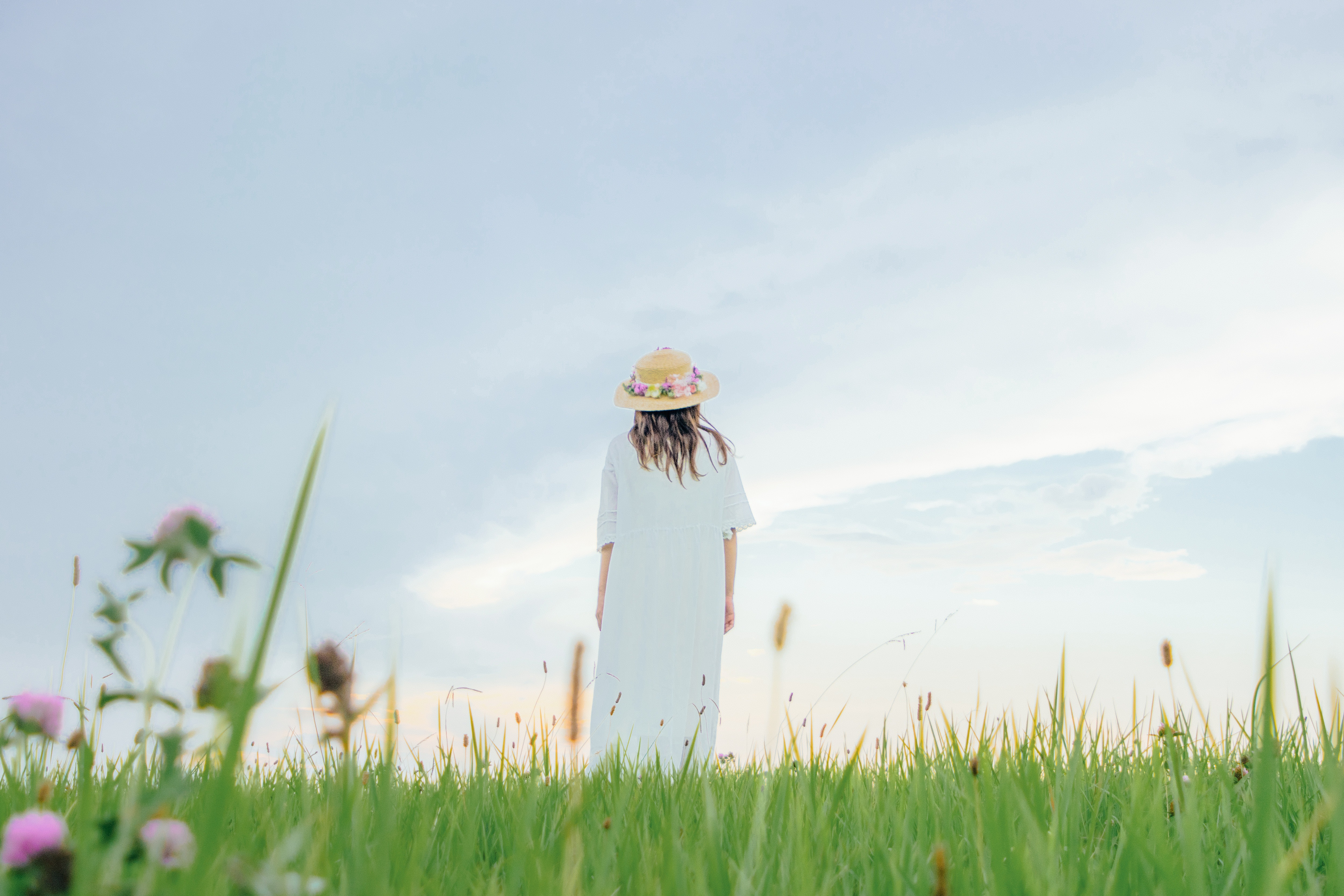 草原で立ちつくす麦わら帽子の女性の写真素材 ぱくたそ