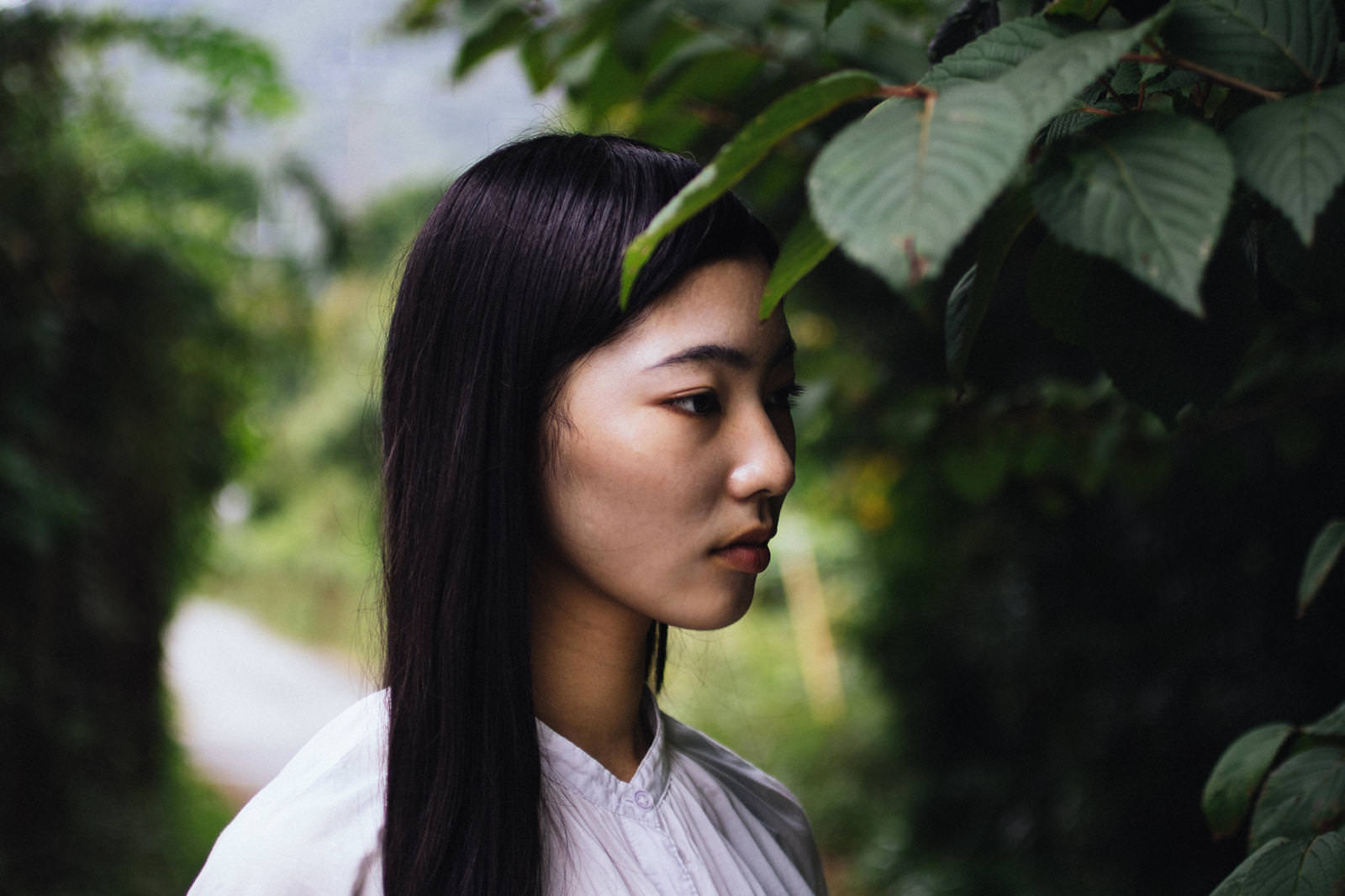 「木陰でぼんやりする女性 | フリー素材のぱくたそ」の写真［モデル：なんこ］