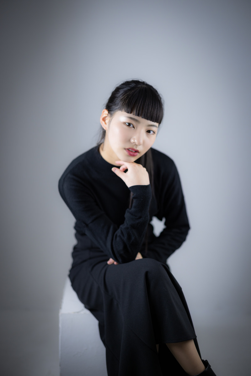 「足を組んで頬杖をつく女性 | フリー素材のぱくたそ」の写真［モデル：なんこ］