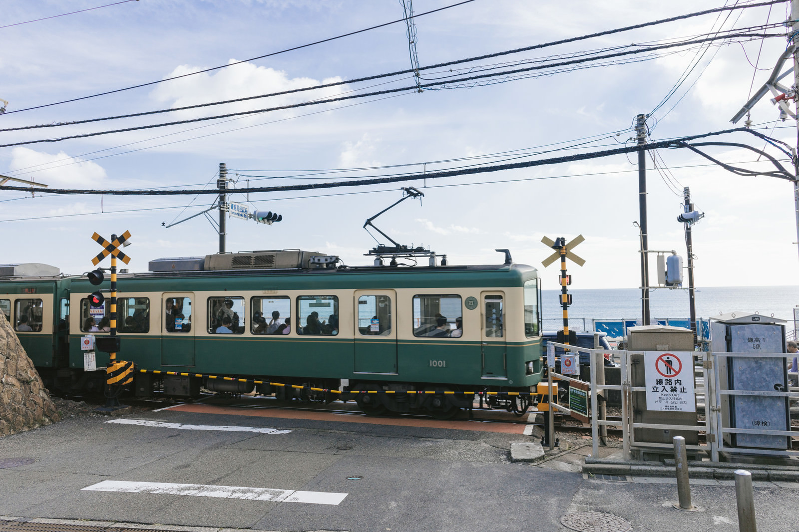 「アニメのワンシーンで登場しそうな鎌倉高校前駅の踏切と江ノ電 | ぱくたそフリー素材」の写真