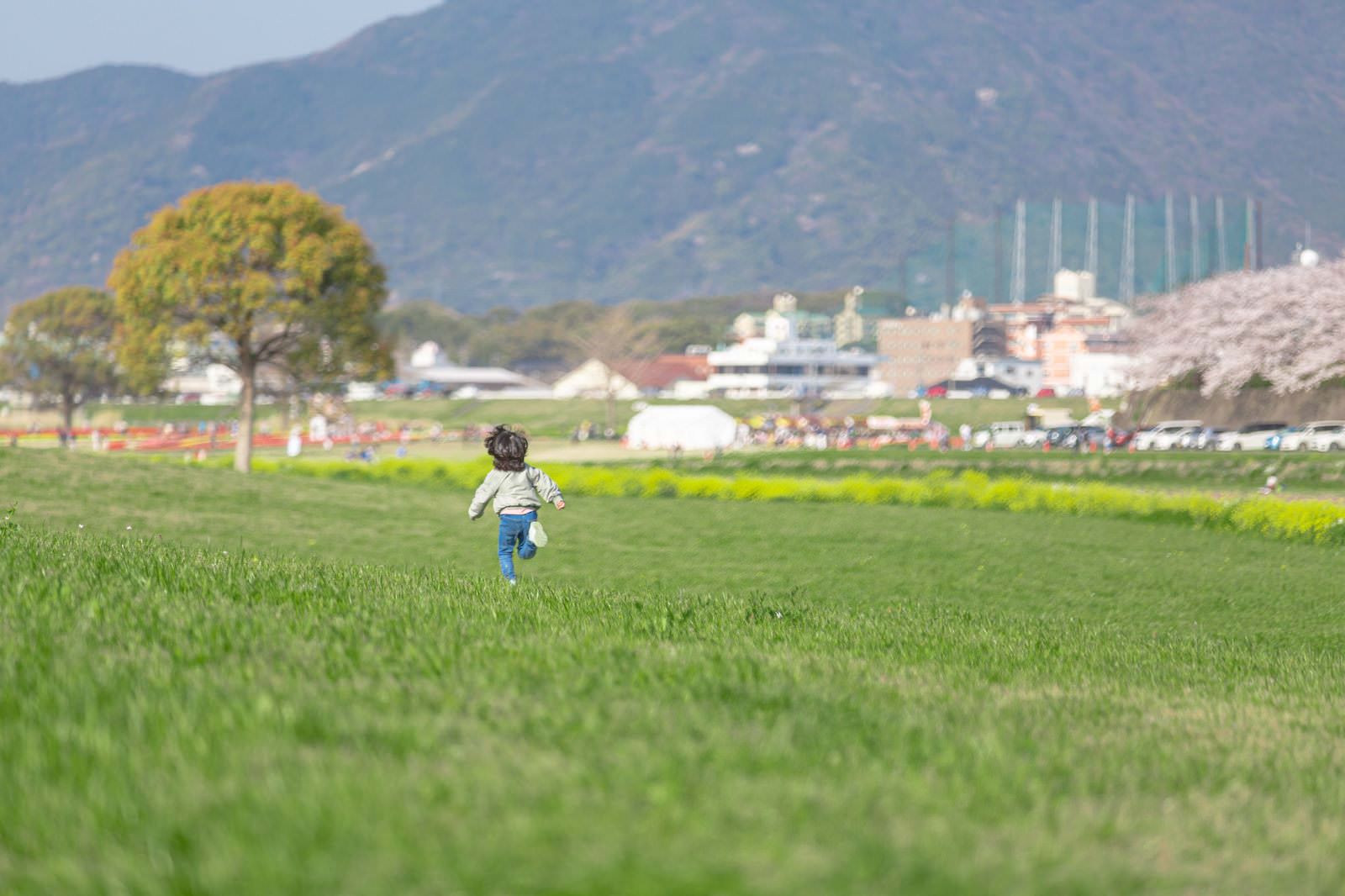 「河川敷を走る子供 | フリー素材のぱくたそ」の写真