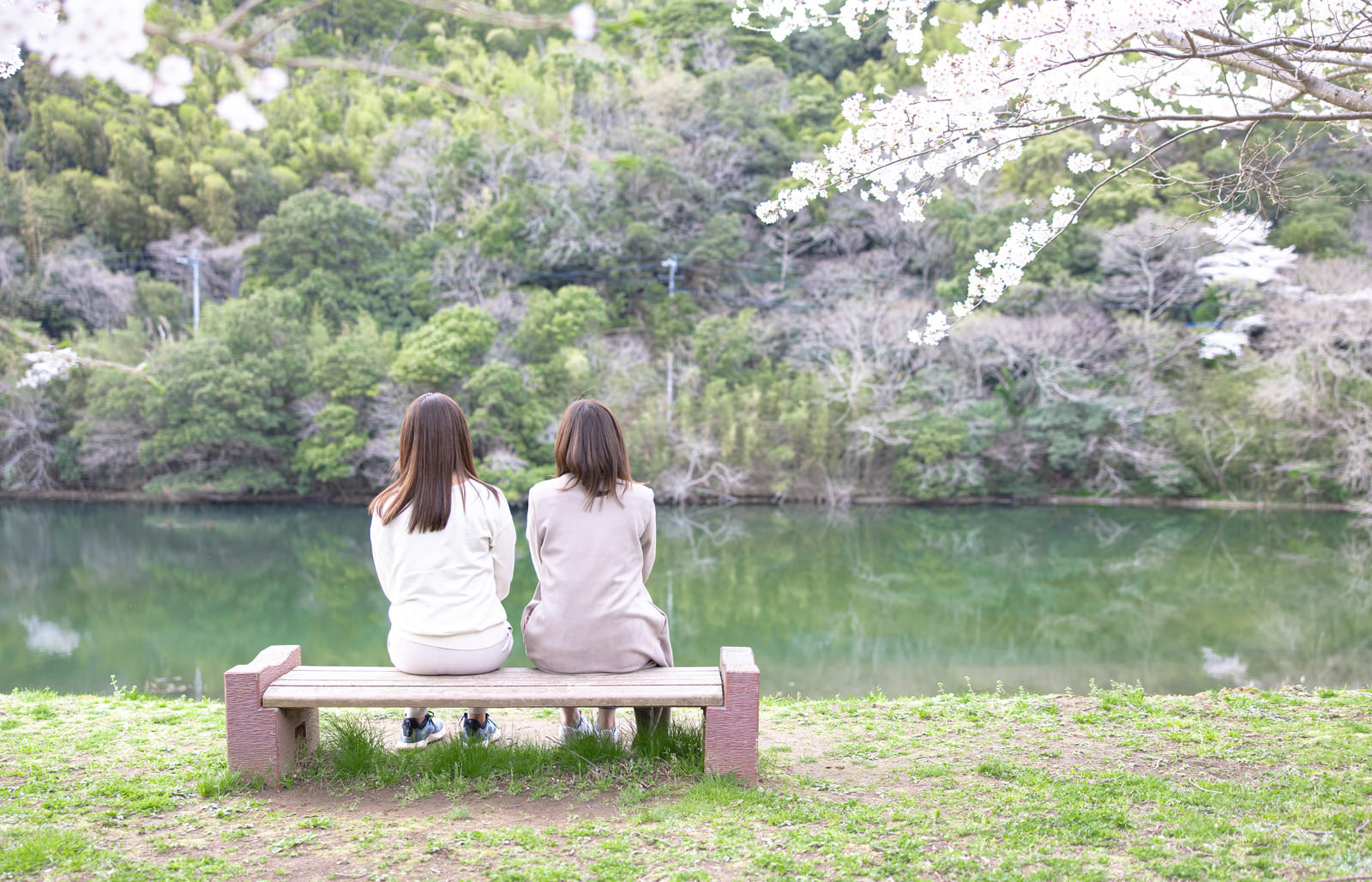 「のおがた内ヶ磯ダムにあるベンチに座る女性ふたり」の写真