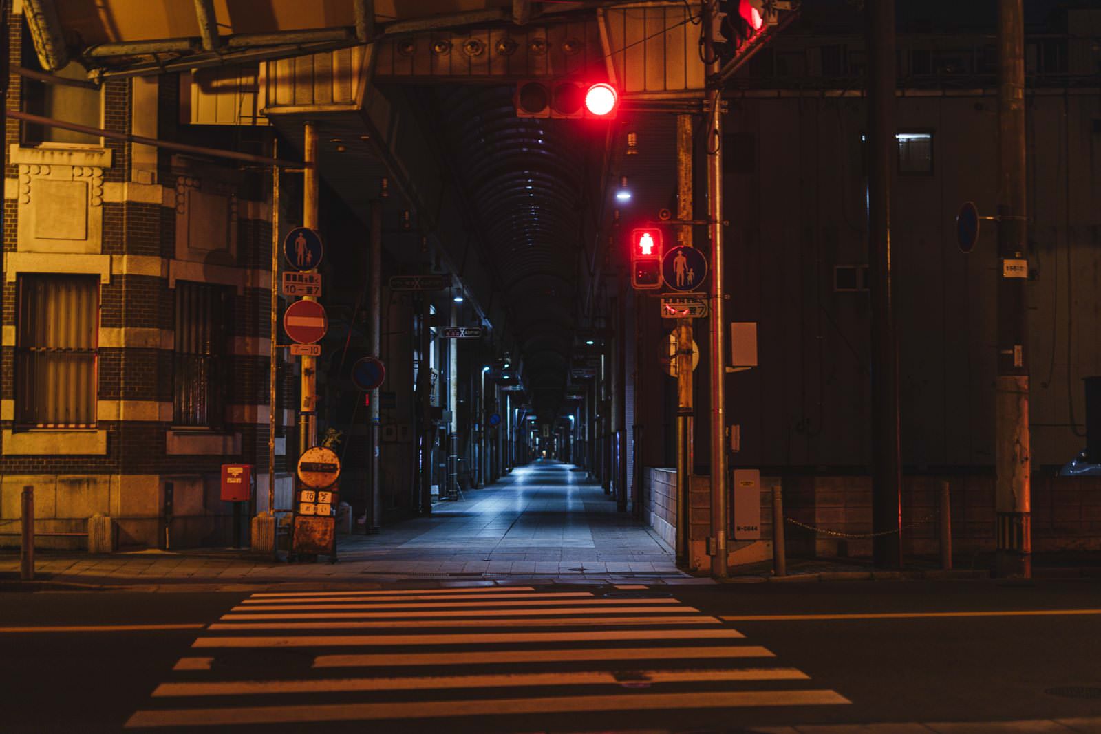 「夜の直方市古町商店街と横断歩道 | フリー素材のぱくたそ」の写真