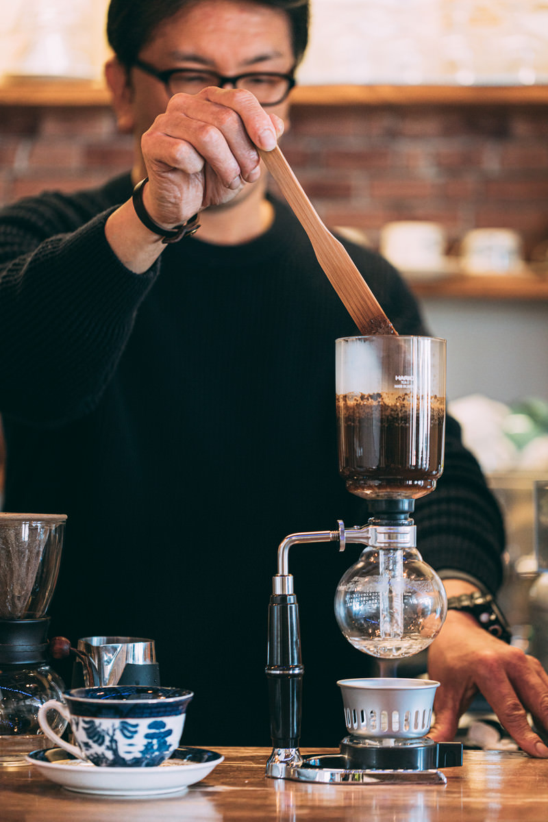 「カフェのマスターがコーヒーを抽出中 | フリー素材のぱくたそ」の写真