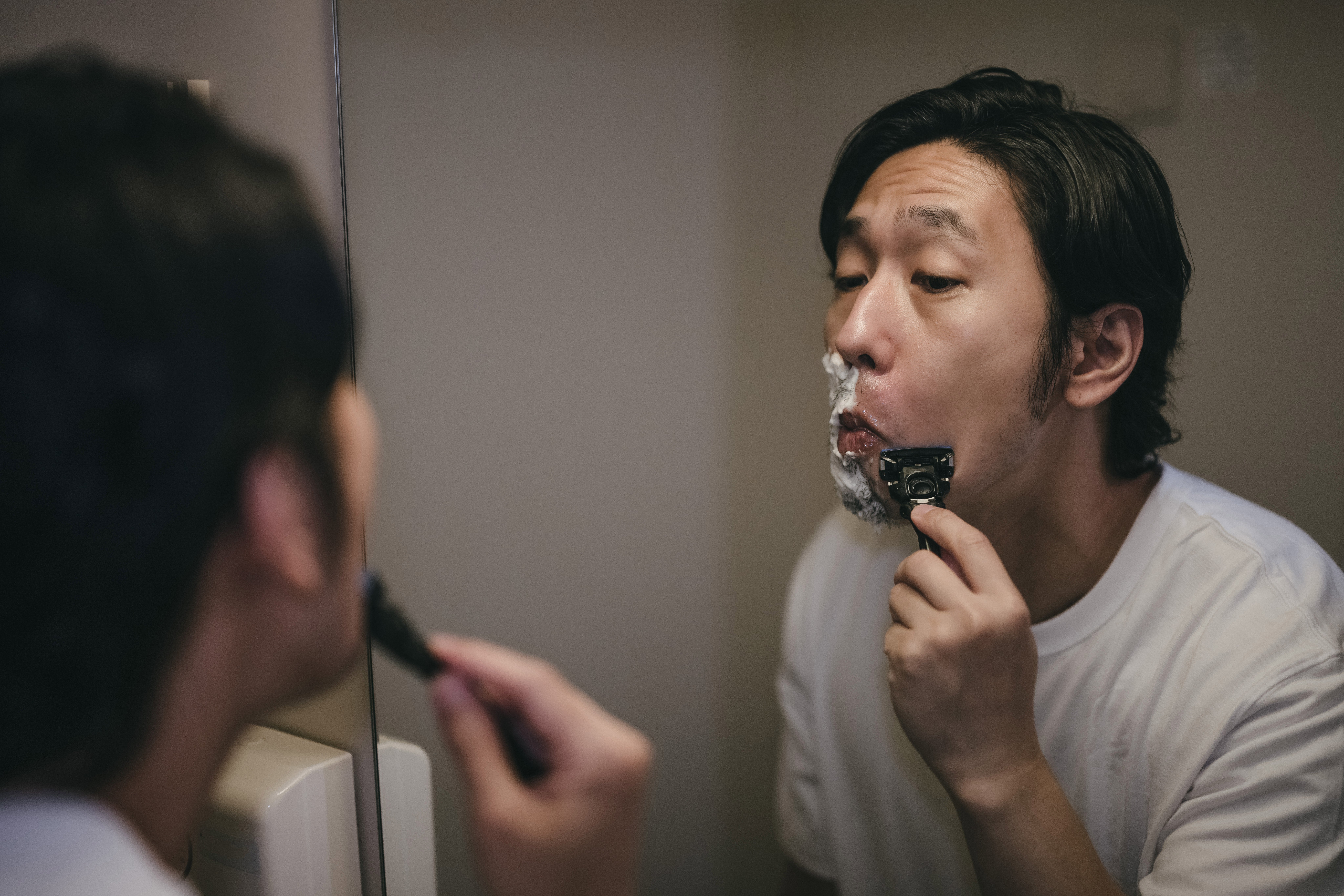 鏡を見ながら髭を剃る男性の写真素材 ぱくたそ