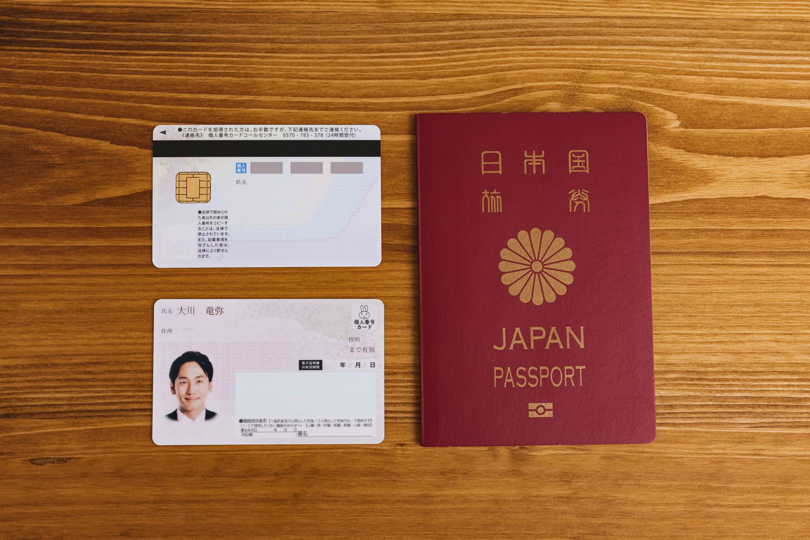 「テーブルに置かれたマイナンバーカードとパスポート」の写真［モデル：大川竜弥］