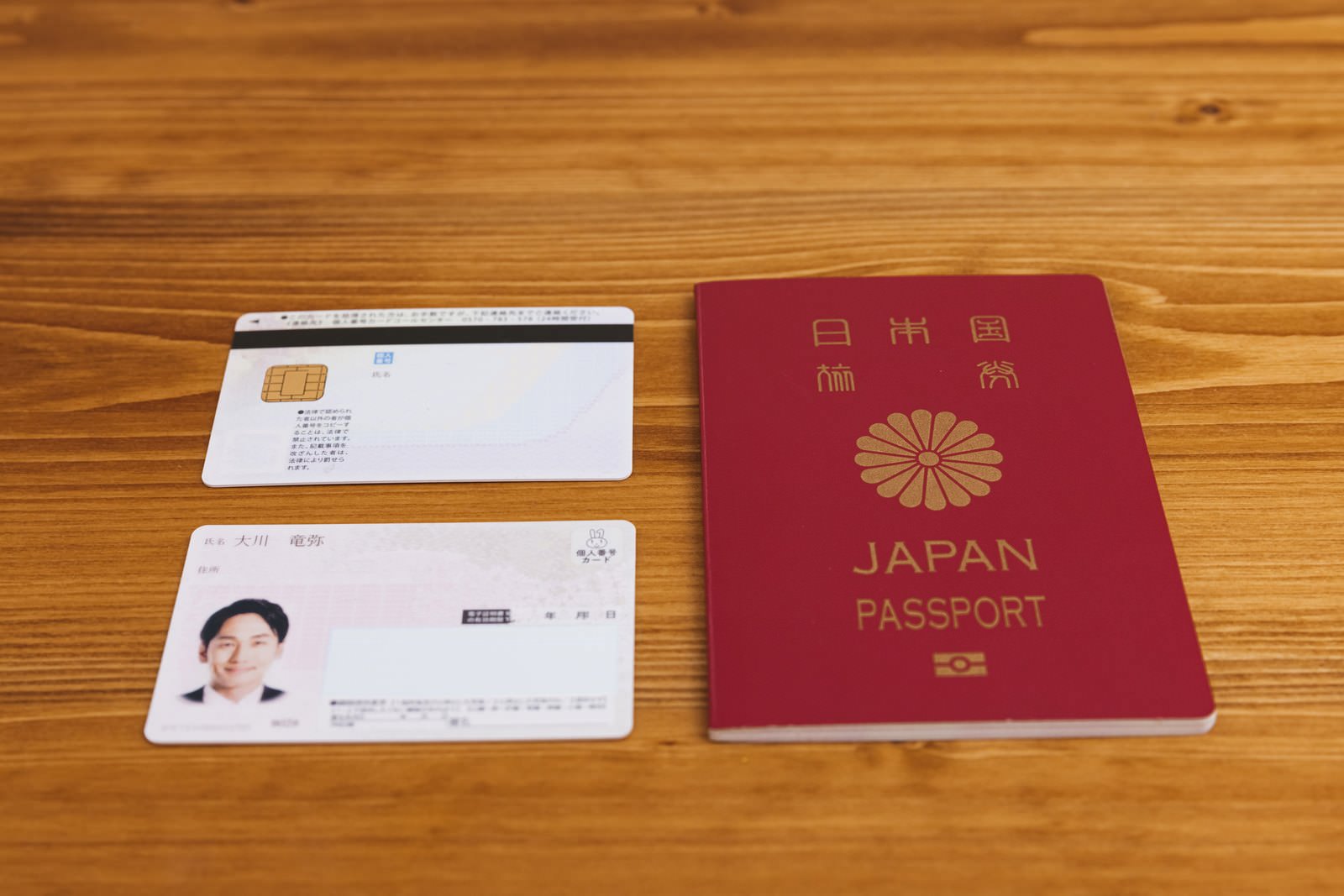 「机に置かれたマイナンバーカードと旅券」の写真［モデル：大川竜弥］