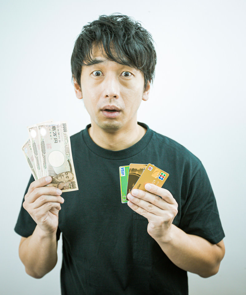 「現金とクレカを持つ男性」の写真［モデル：大川竜弥］