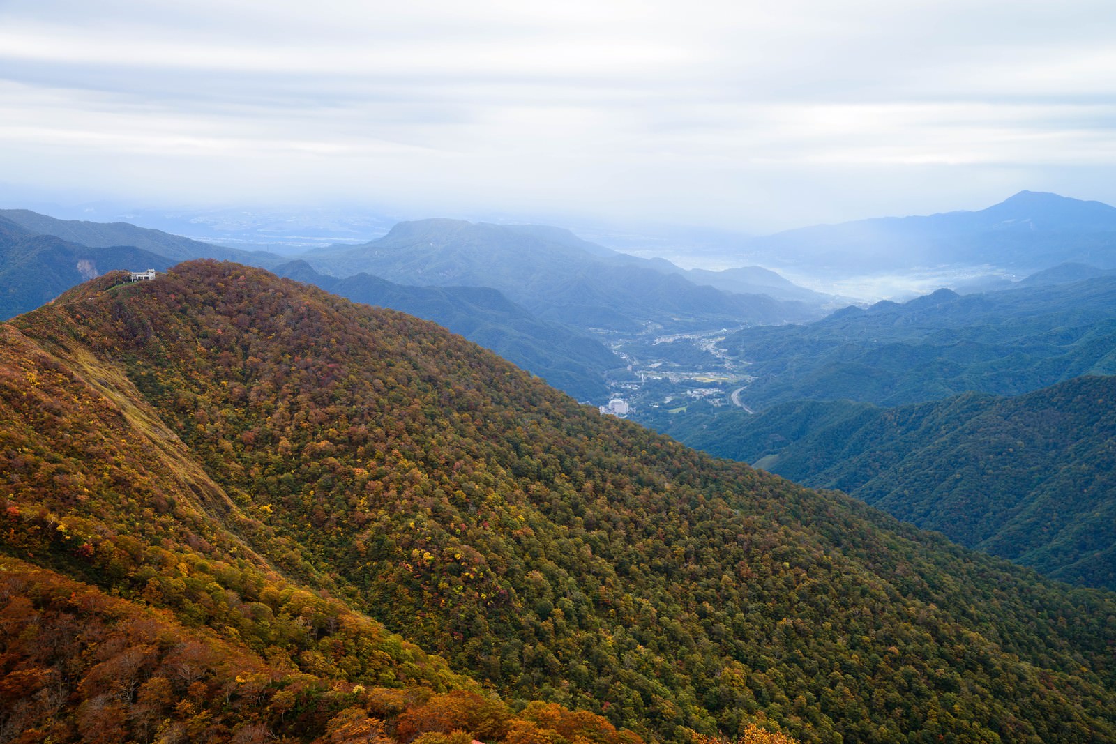 「色づき始める谷川岳と眼下に広がる町 | フリー素材のぱくたそ」の写真