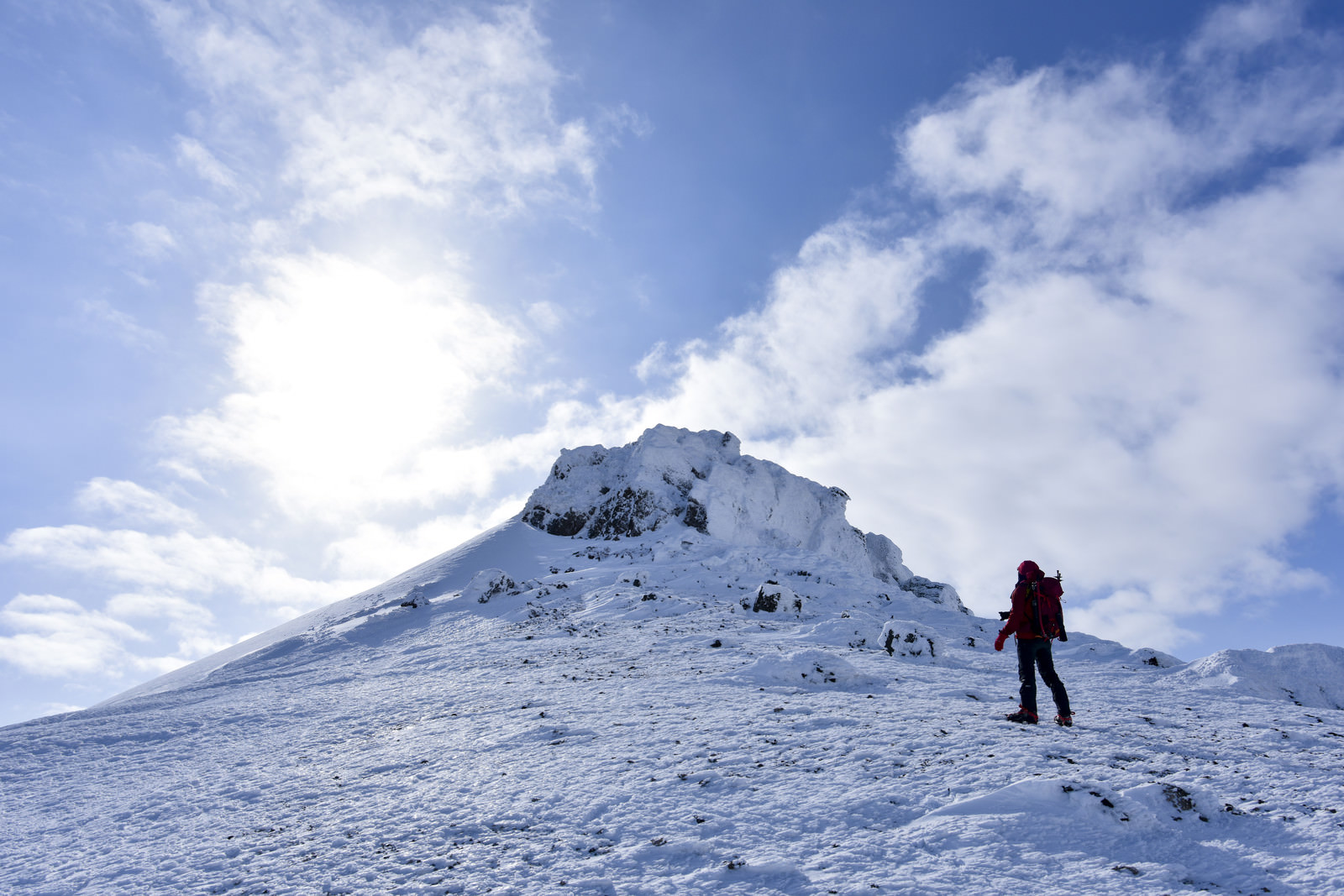 「安達太良山山頂を眺める赤い登山者」の写真