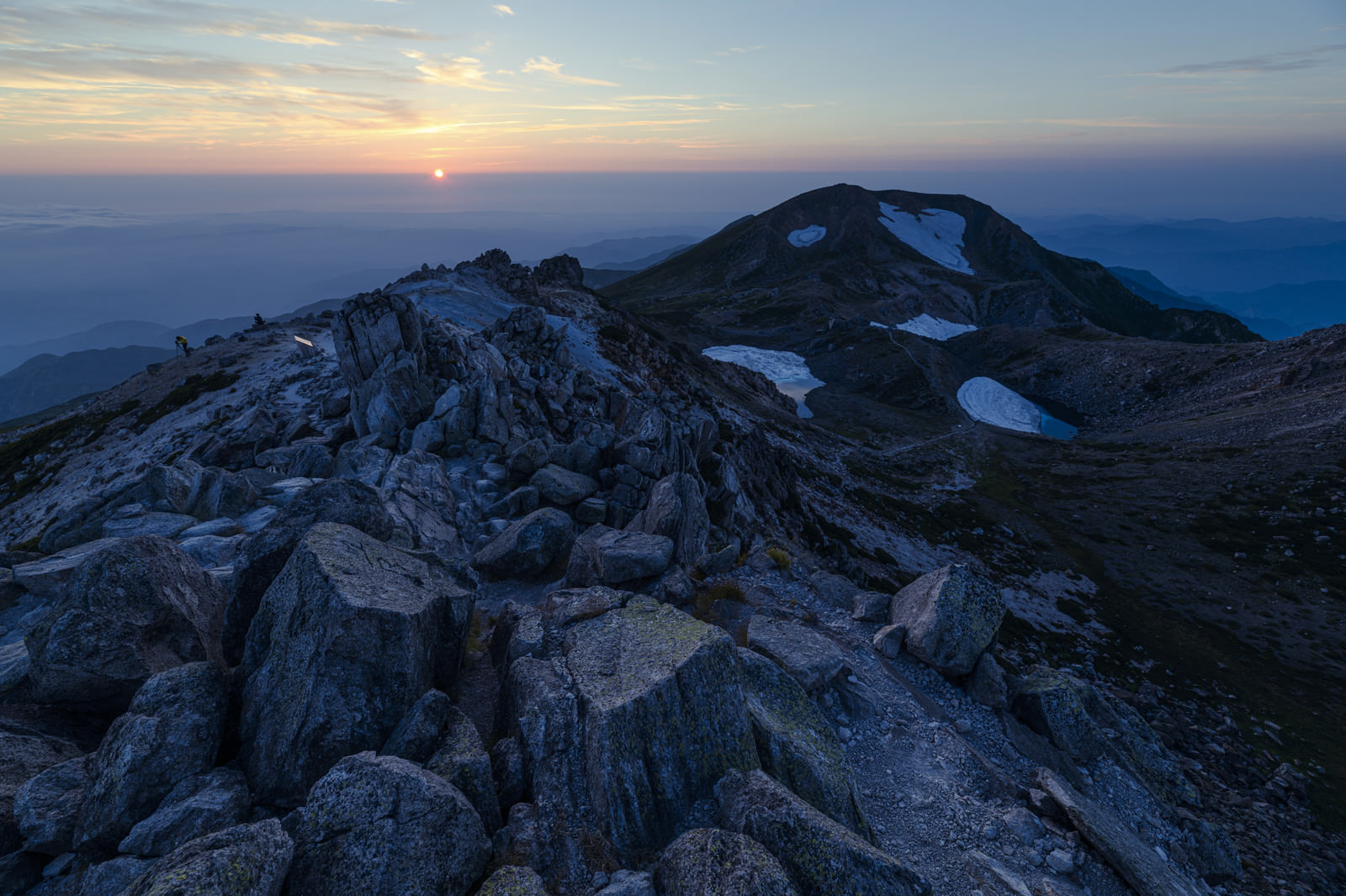 「御前峰の荒々しく積み重なった岩と沈みゆく太陽（白山） | フリー素材のぱくたそ」の写真