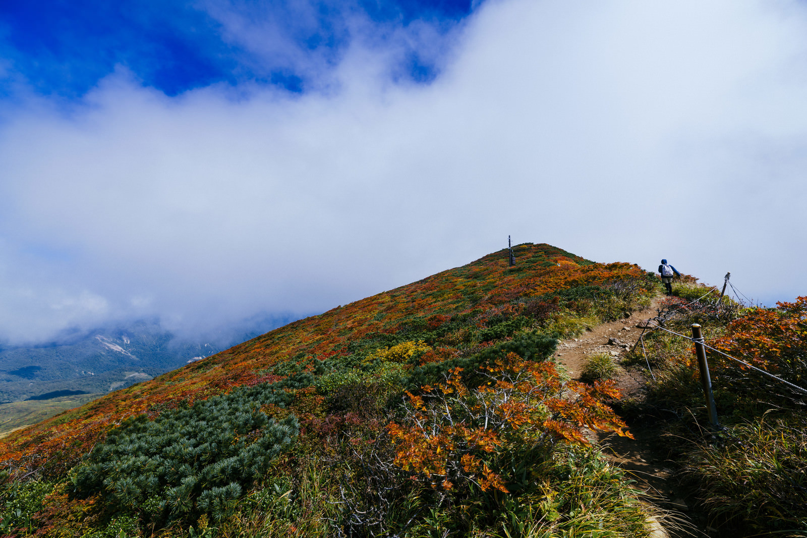 「雲の合間に見える栗駒山の紅葉 | フリー素材のぱくたそ」の写真