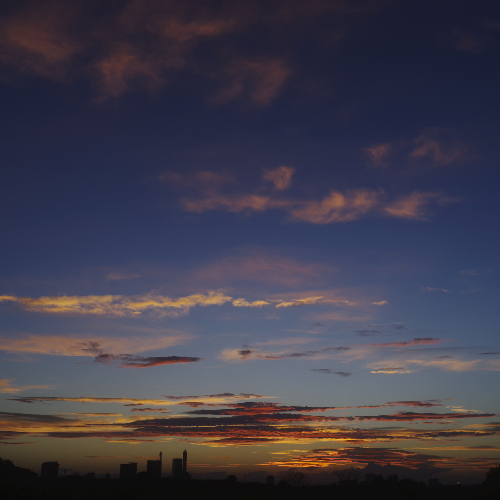 「青と赤に彩られたさいたま新都心の空 | フリー素材のぱくたそ」の写真