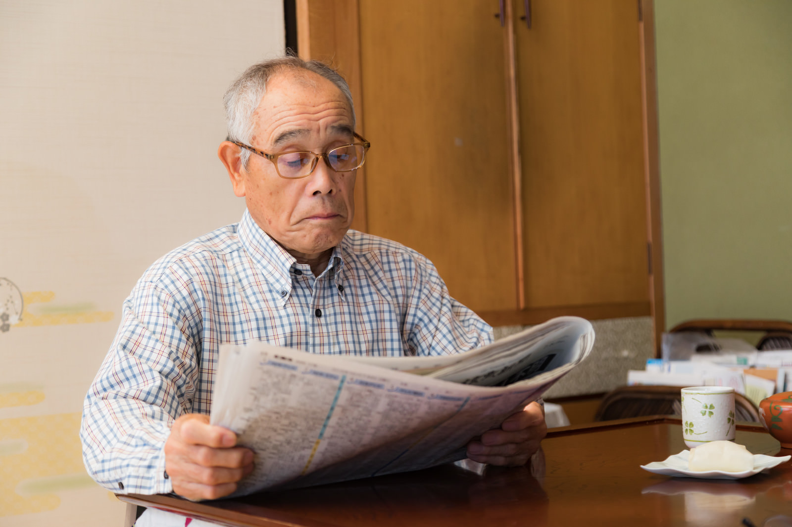 「朝刊に目を通すお爺さん | フリー素材のぱくたそ」の写真［モデル：まーちゃん］