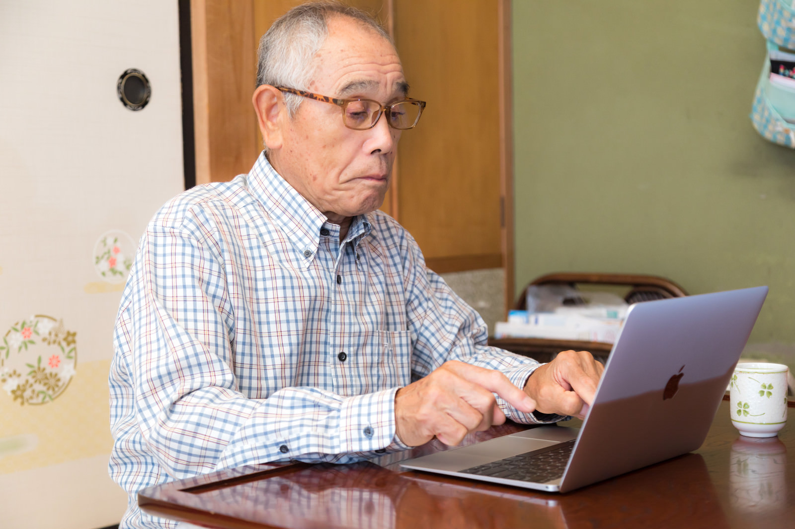 「MacBook でブログを書くお爺さんの様子」の写真［モデル：まーちゃん］