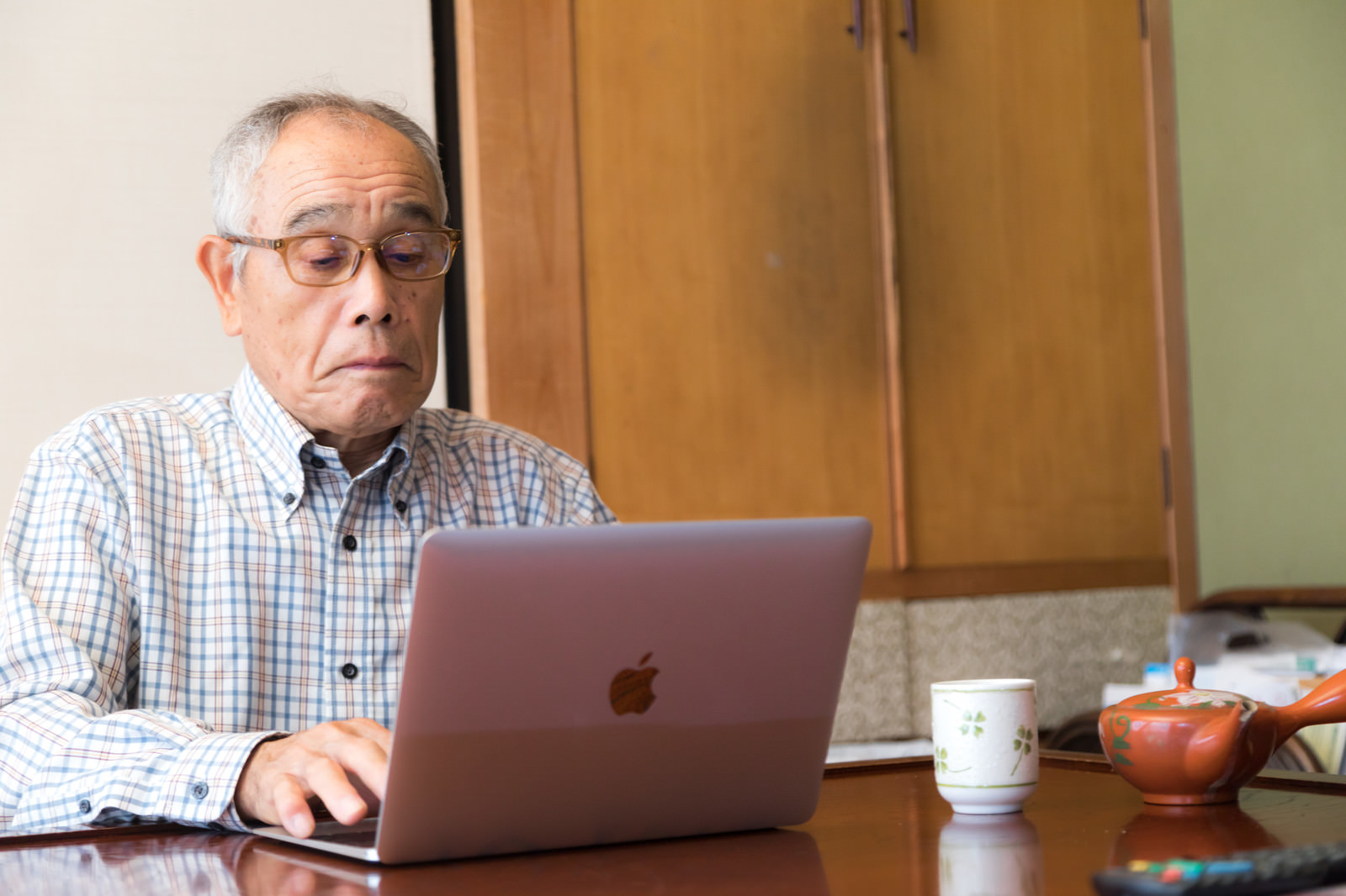 「株価のチェックに余念がない高齢者の男性」の写真［モデル：まーちゃん］
