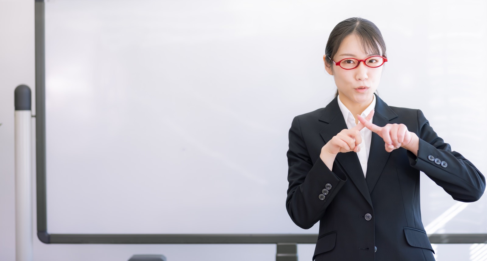 「不合格サインを出す女性講師」の写真［モデル：SAKI］