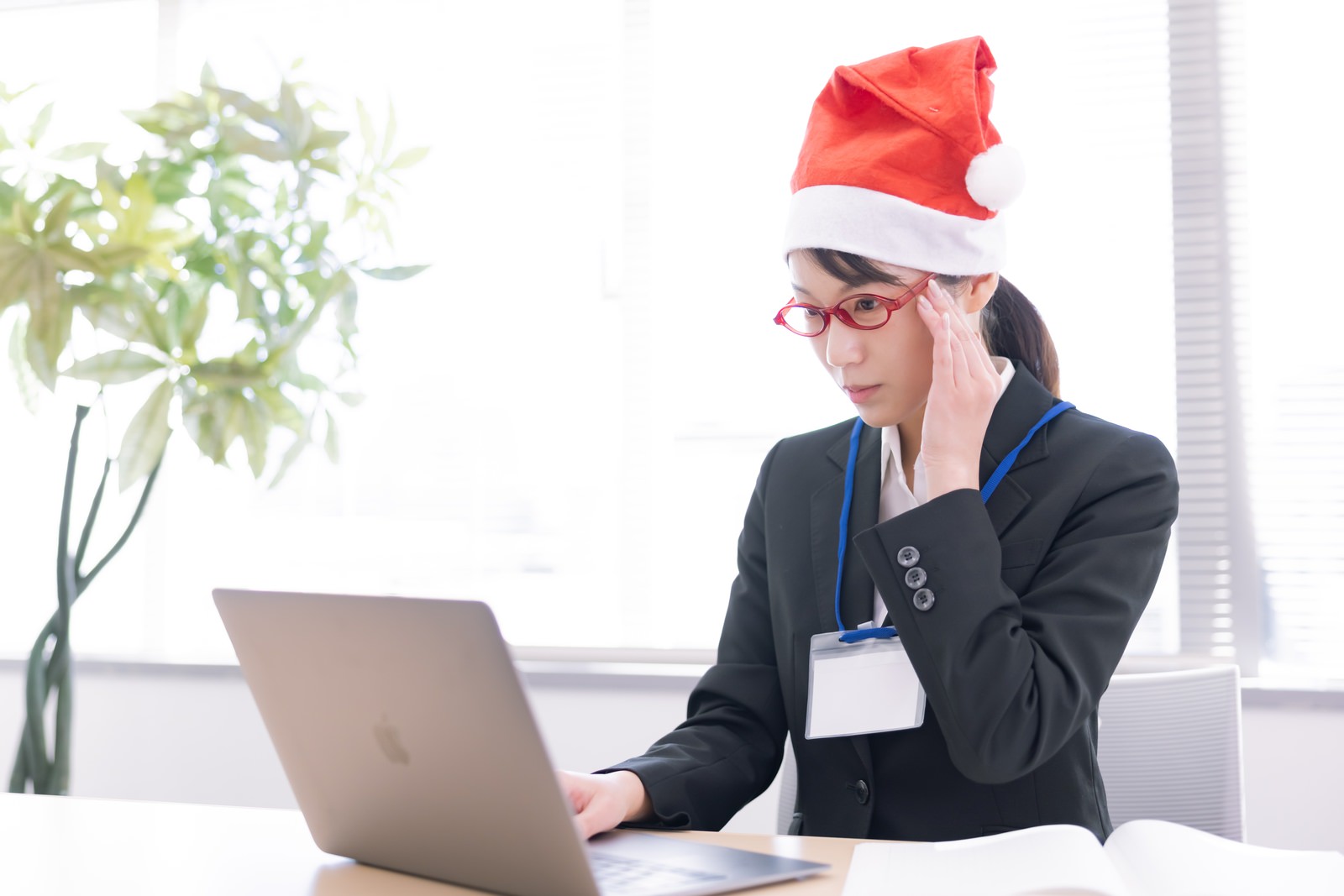 「クリスマス時期はサンタ帽をかぶる女性社員 | フリー素材のぱくたそ」の写真［モデル：SAKI］