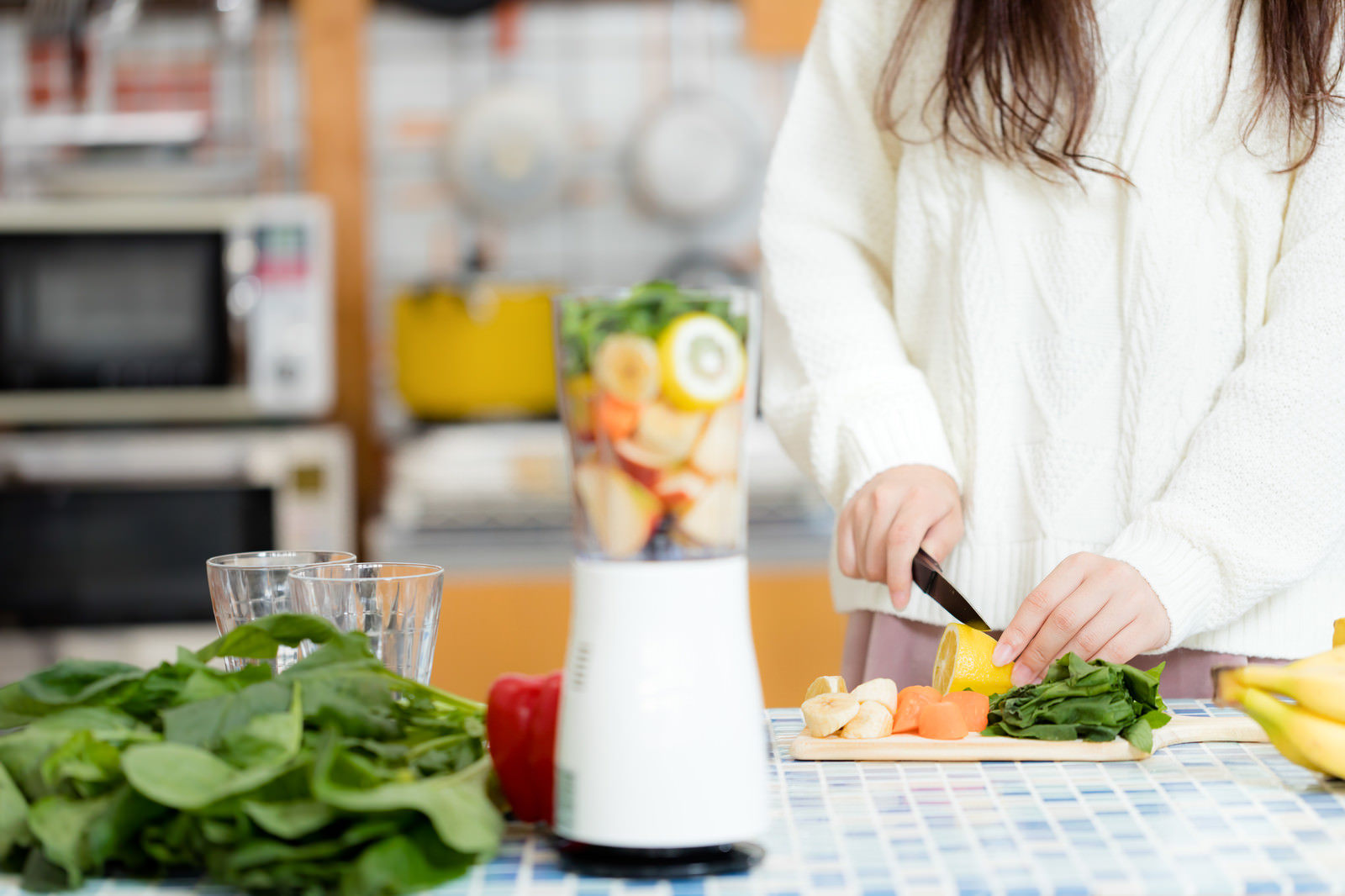 キッチンでスムージー用の野菜をカットする女性の写真を無料ダウンロード フリー素材 ぱくたそ