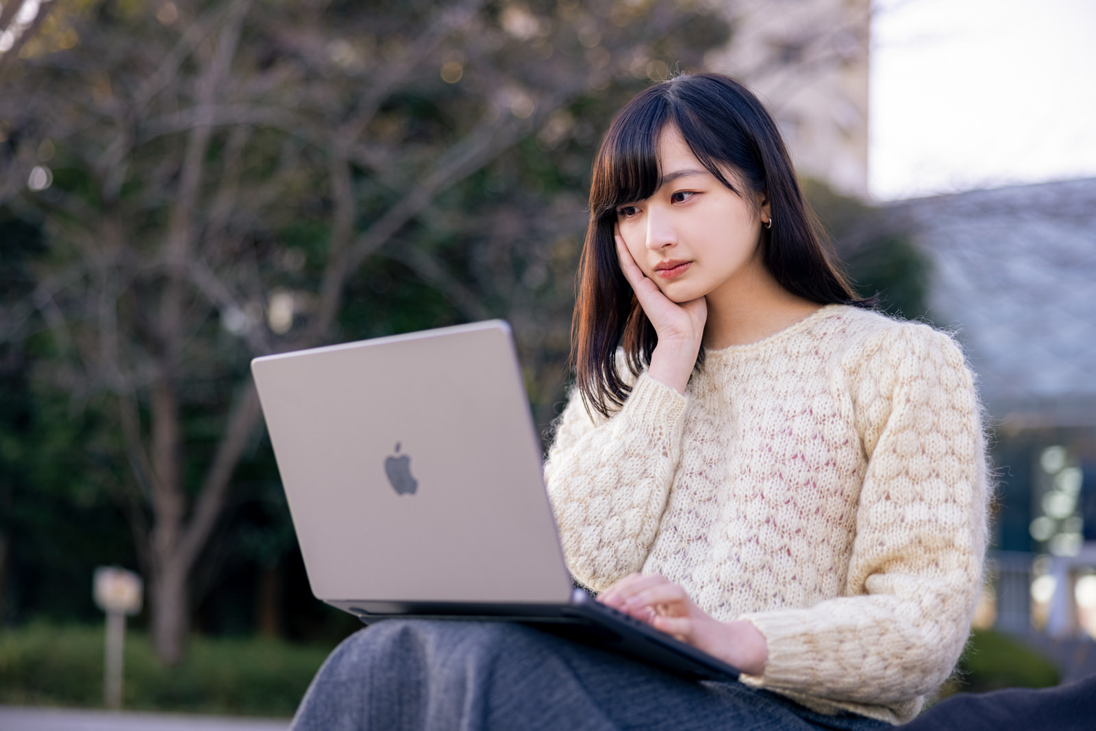 「考えながらメッセージを打つ女性 | フリー素材のぱくたそ」の写真［モデル：井隼そら］