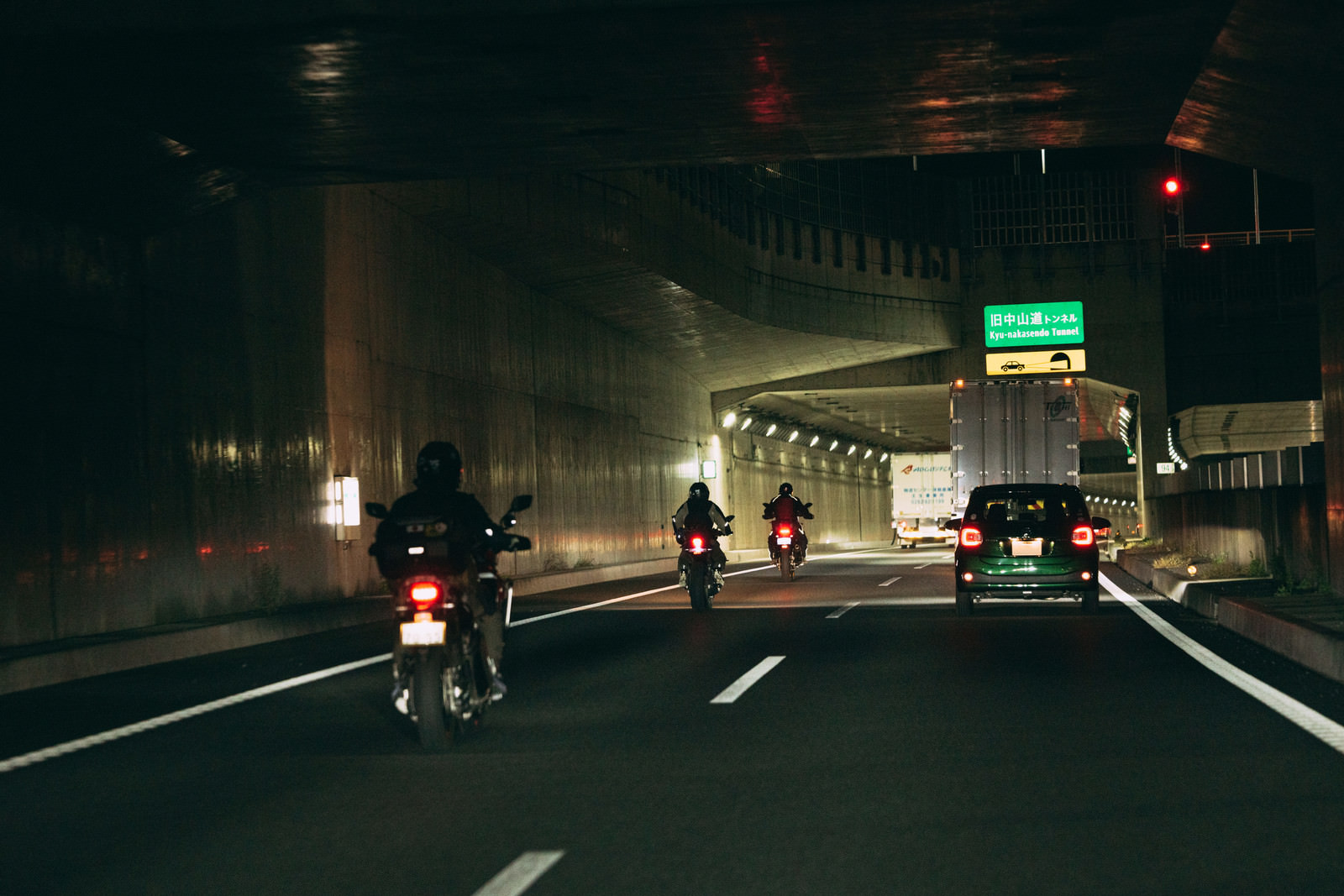「夜間走行するバイクと自動車」の写真