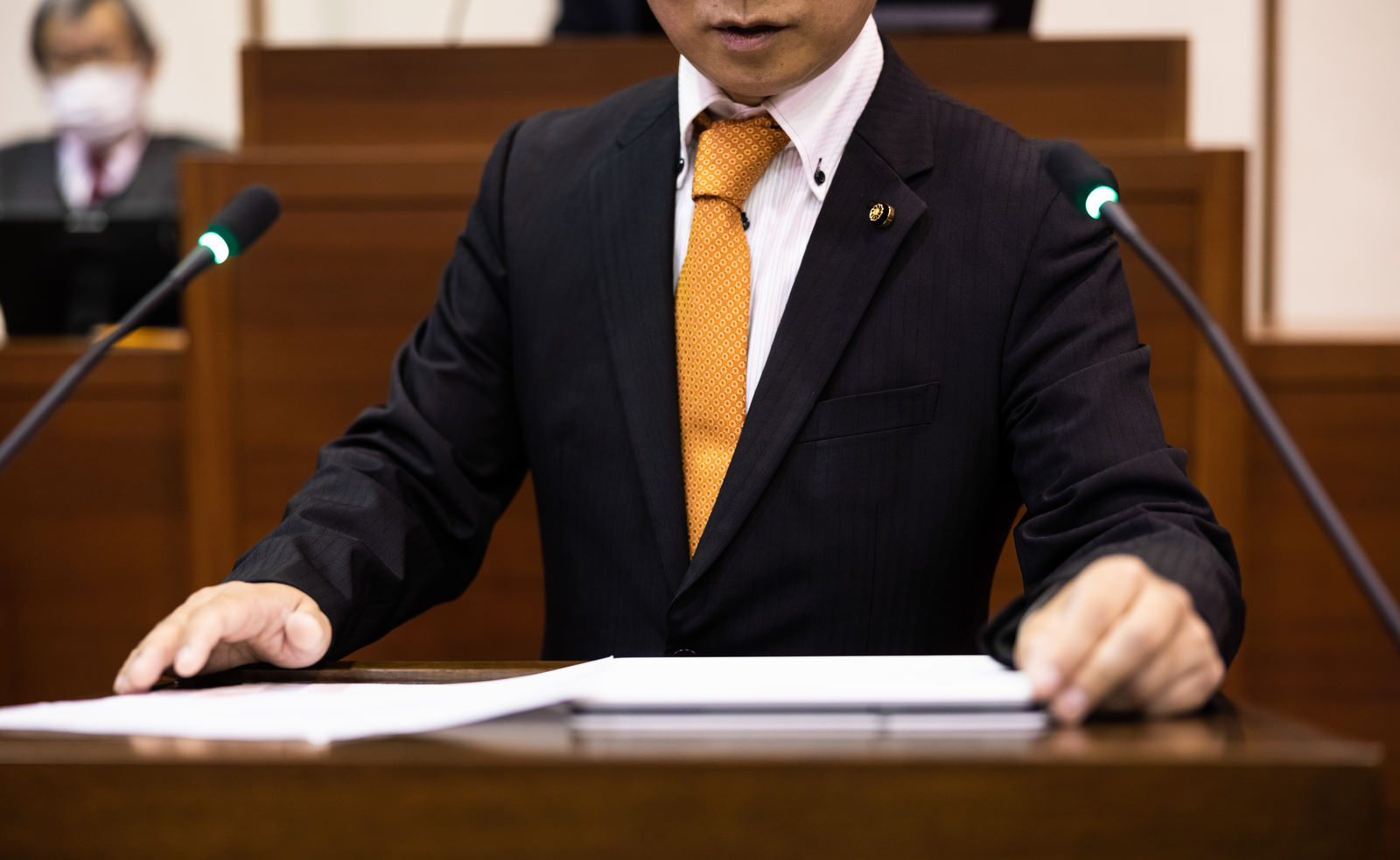 「市議会で発言する議員」の写真