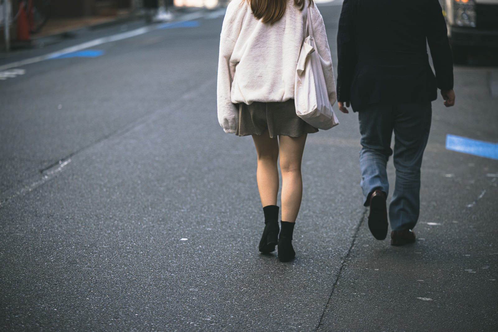 「新宿路地裏を歩く男女の後ろ姿」の写真