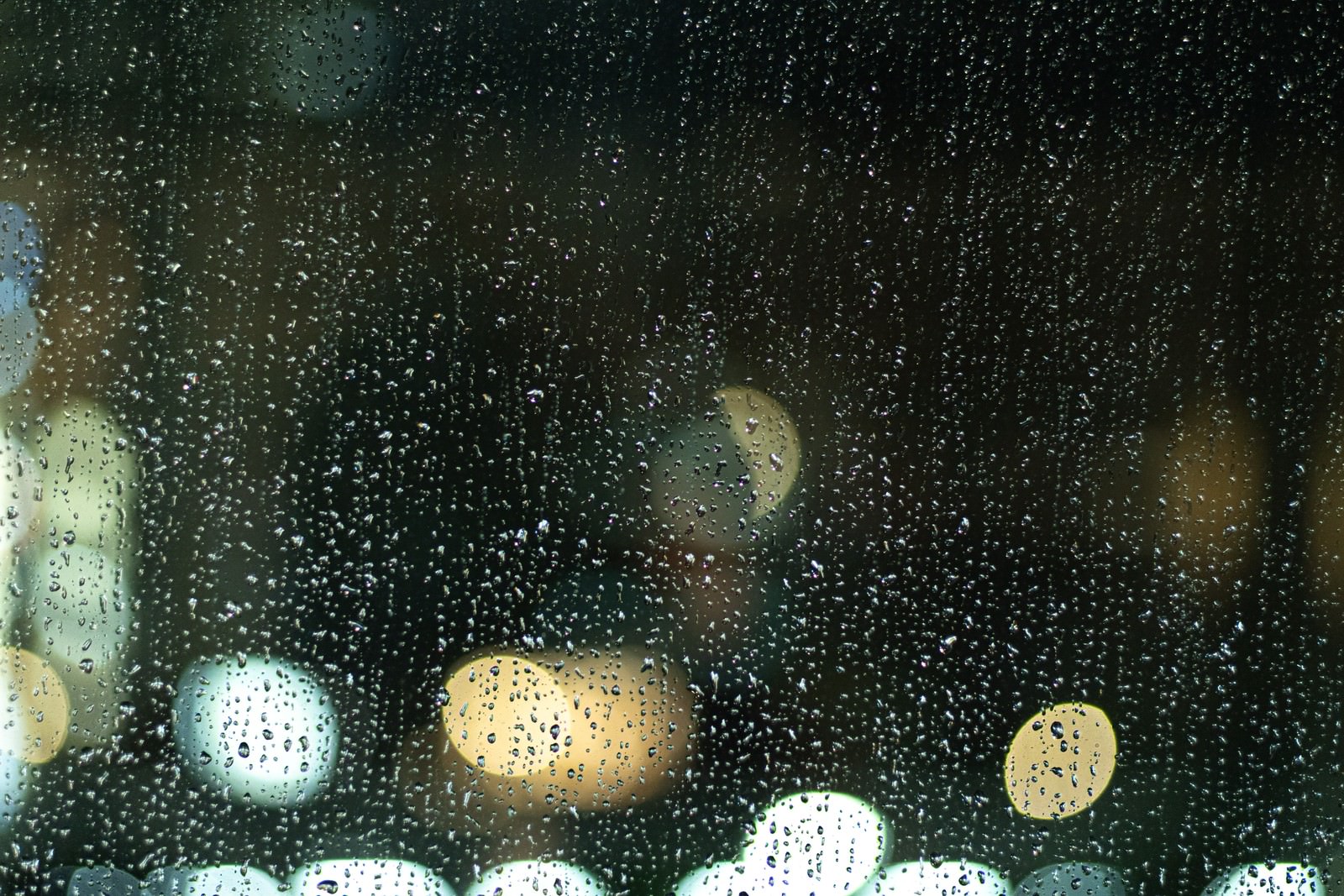 窓ガラス一面に残る雨粒と街の明かりの写真素材を拡大・トリミング加工（JPG画像） ぱくたそ
