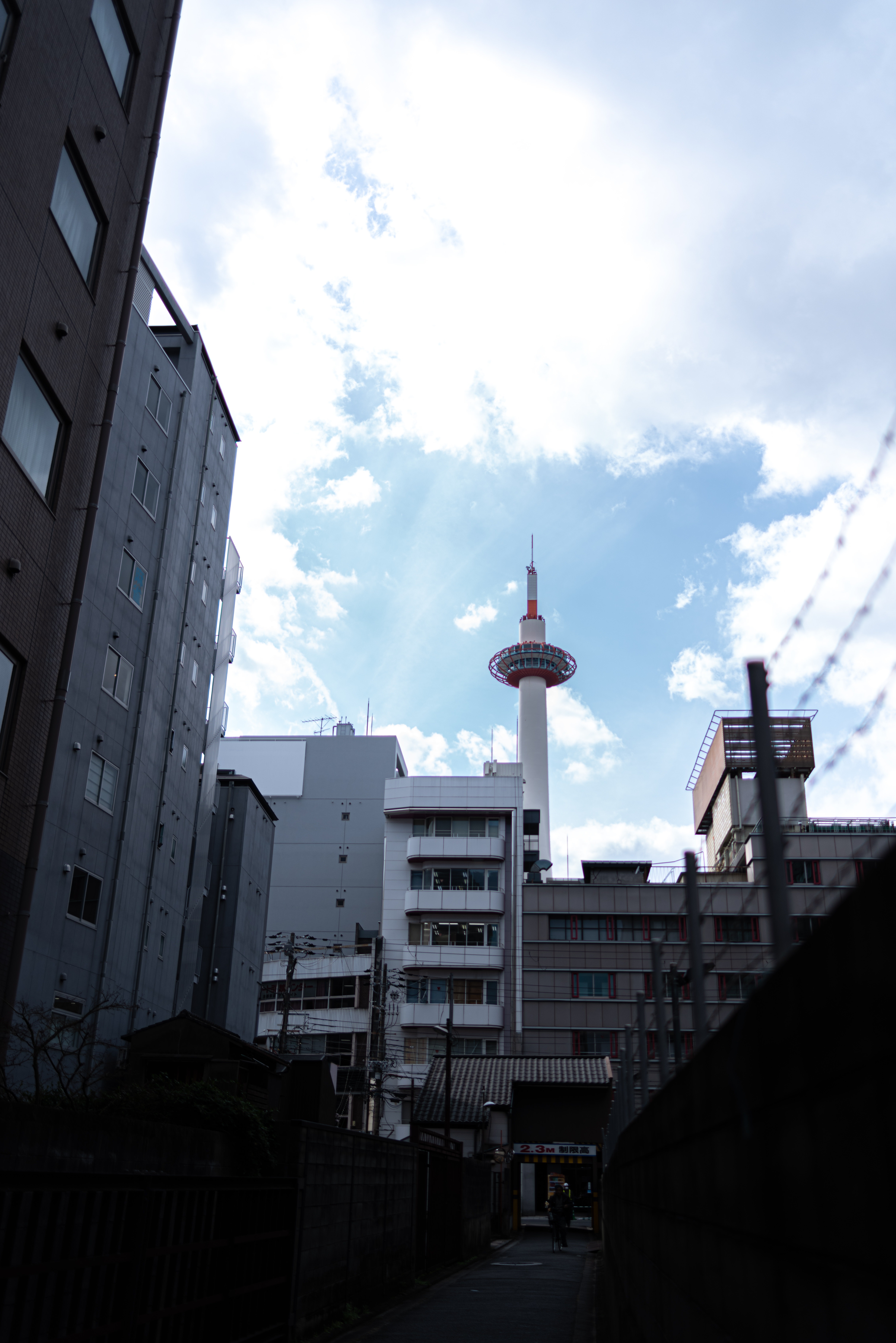 路地裏から見上げた京都タワーの写真素材 ぱくたそ