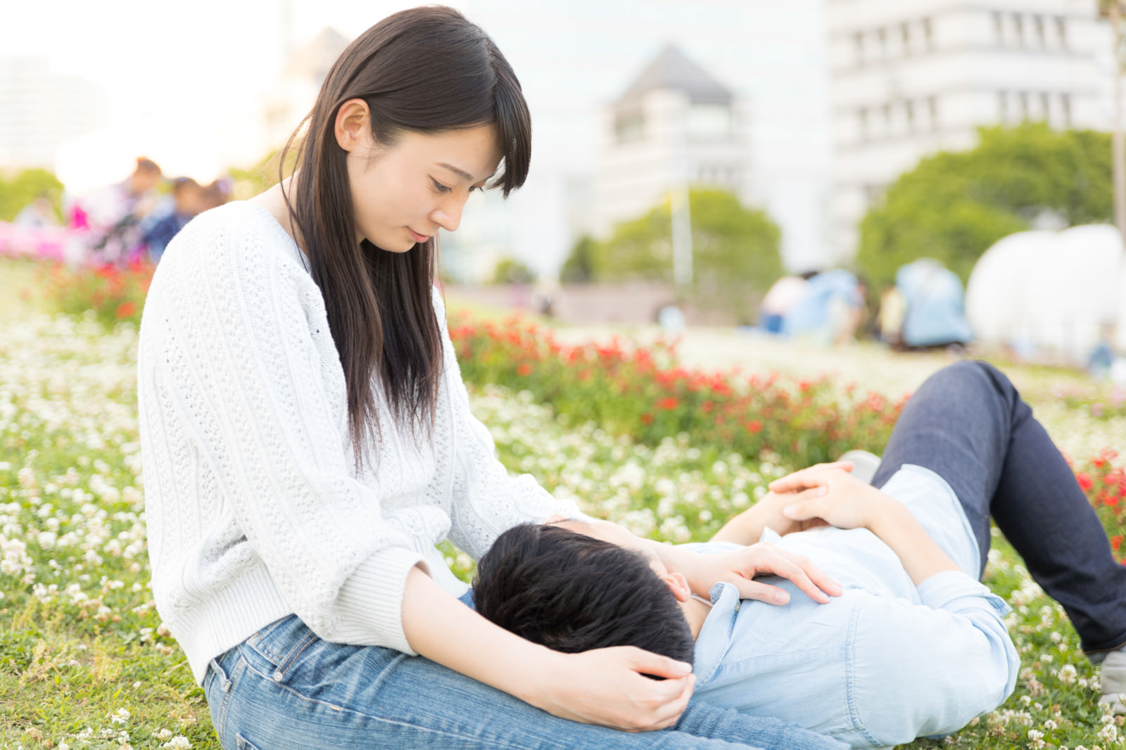 芝生の上で膝枕とかしちゃう系カップルの写真素材 ぱくたそ