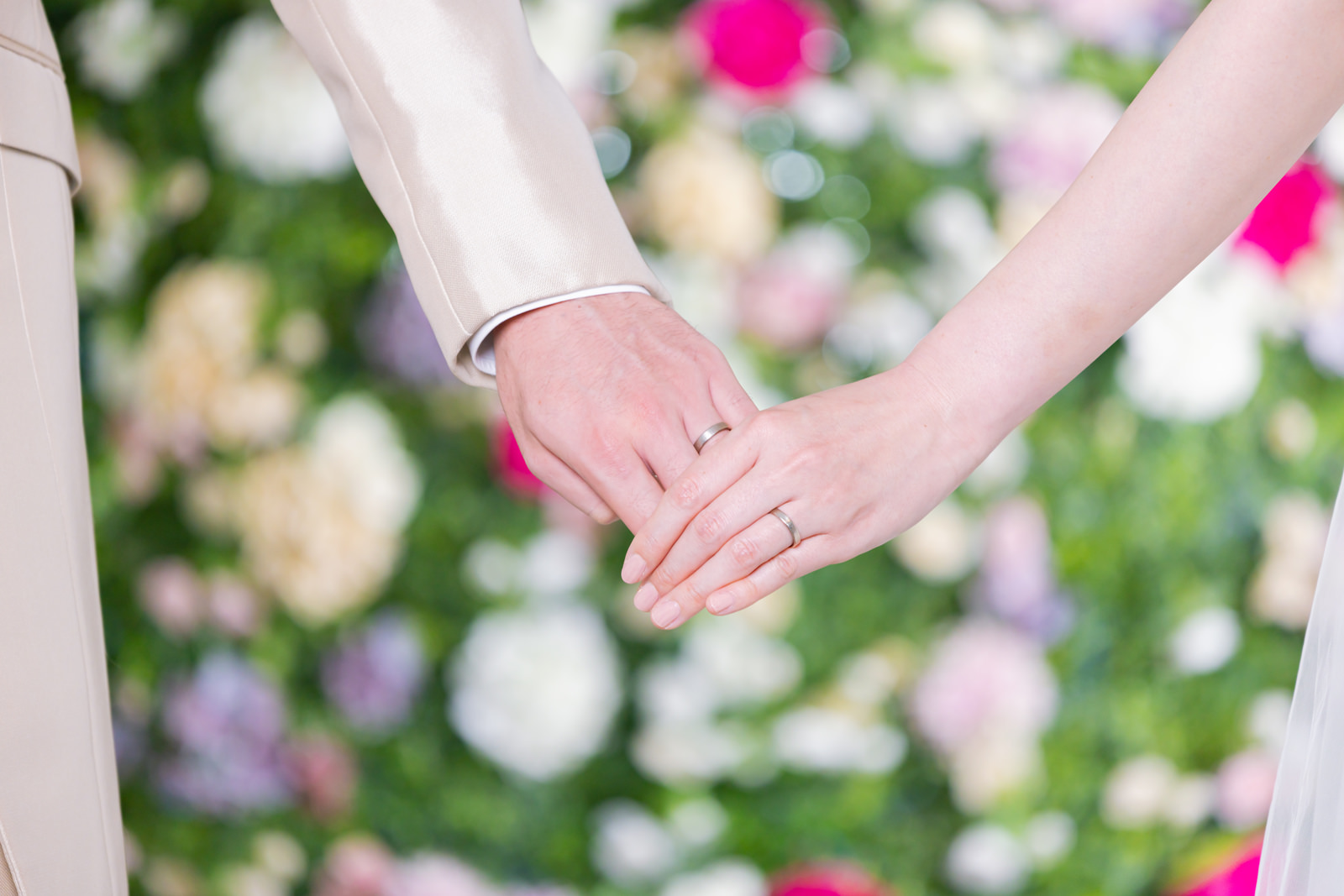「結婚指輪を見えるように手を握り合う新郎新婦 | フリー素材のぱくたそ」の写真［モデル：たけべともこ］