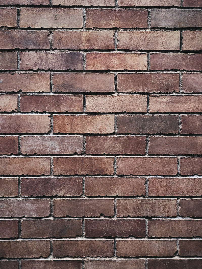 「煉瓦のかけが目立つ色褪せたレンガ壁（テクスチャー） | フリー素材のぱくたそ」の写真