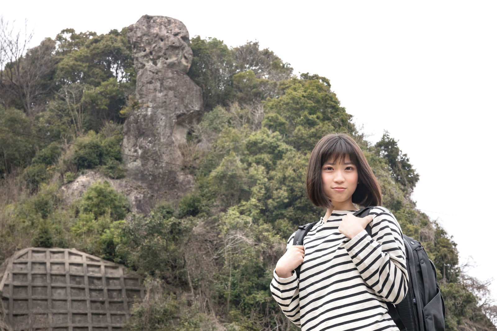 「鯖くさらかし岩とページを探す女性 | フリー素材のぱくたそ」の写真［モデル：塩田みう］