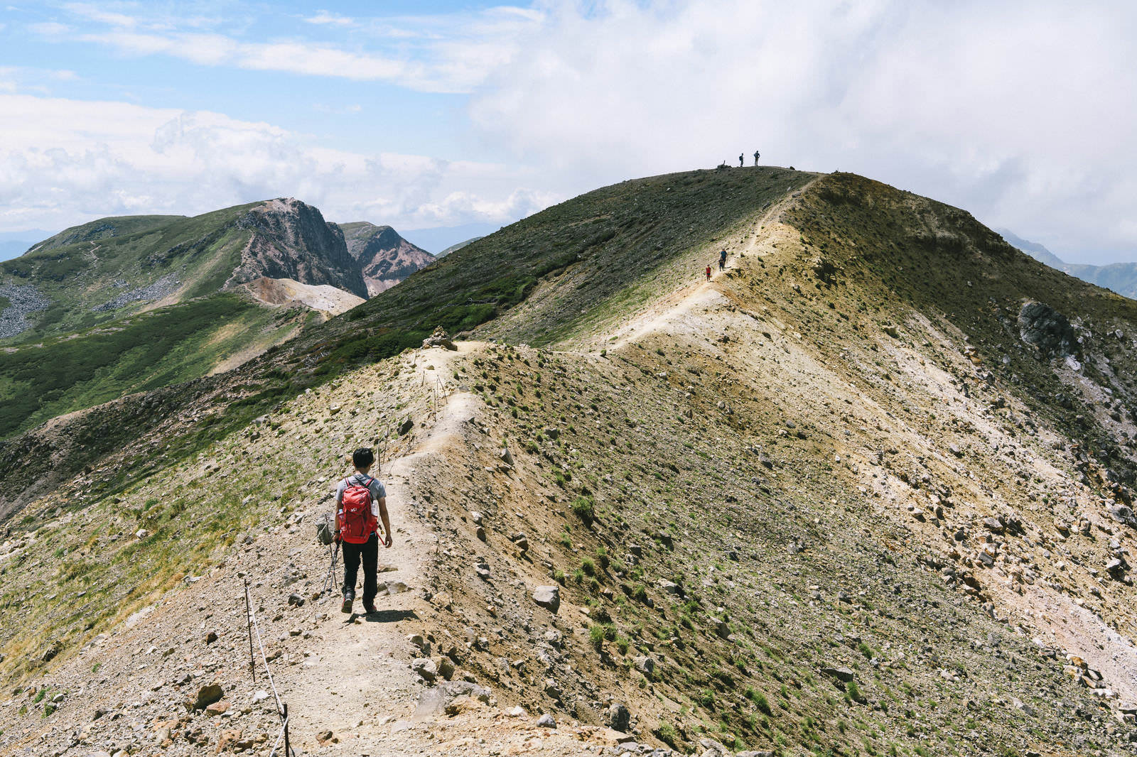 「十勝岳から上ホロカメットク山へ歩く登山者」の写真
