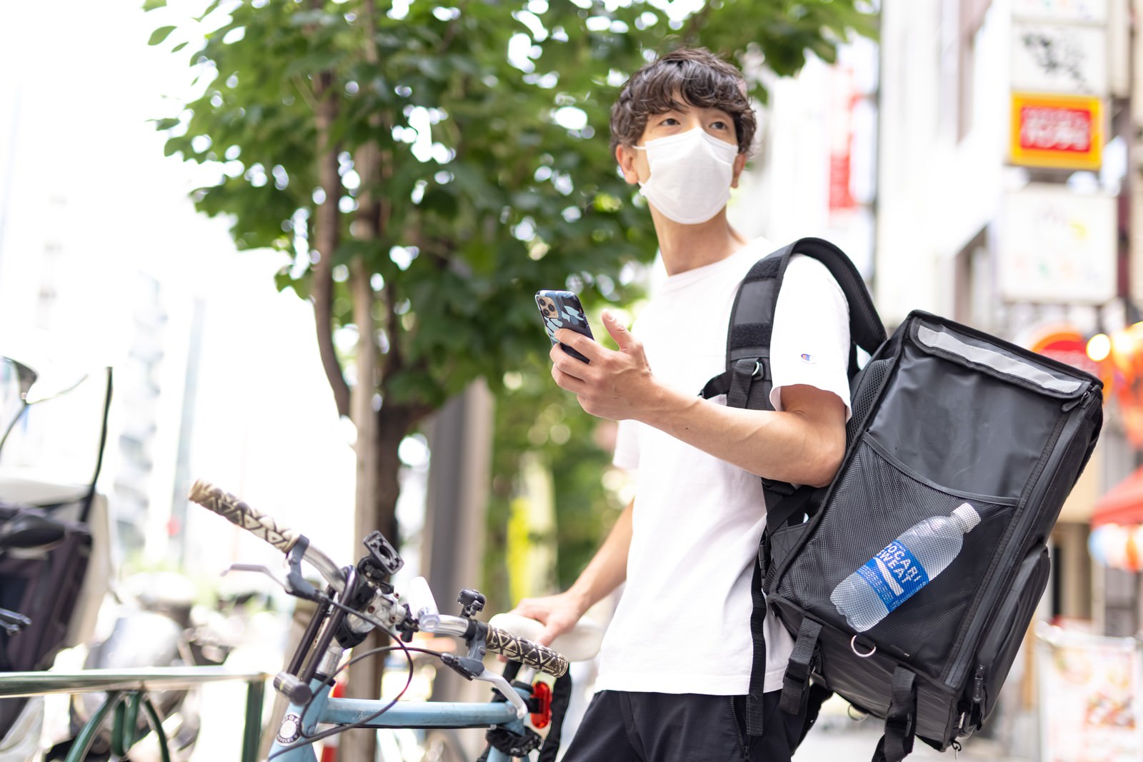 「ゴーストレストランなので依頼先の店舗を探しても見当たらない様子の配達員 | フリー素材のぱくたそ」の写真［モデル：TSURUTAMA］