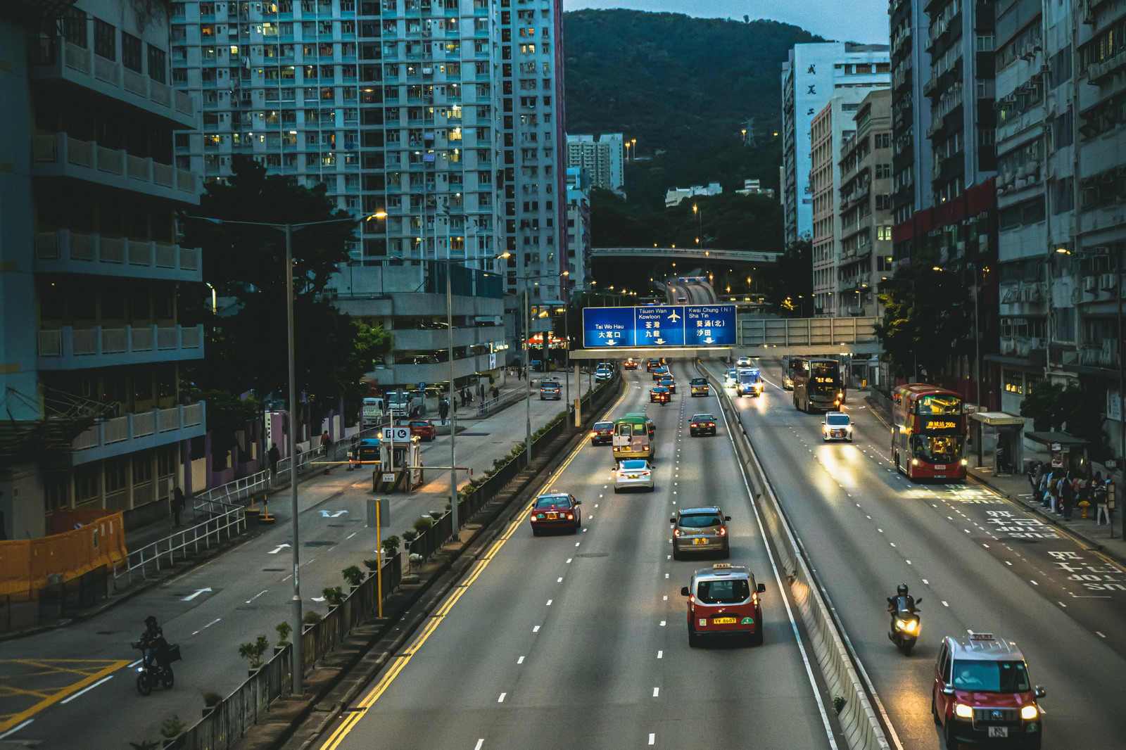 「日が沈み始めた歩道橋からみた香港(葵涌)の通り | フリー素材のぱくたそ」の写真