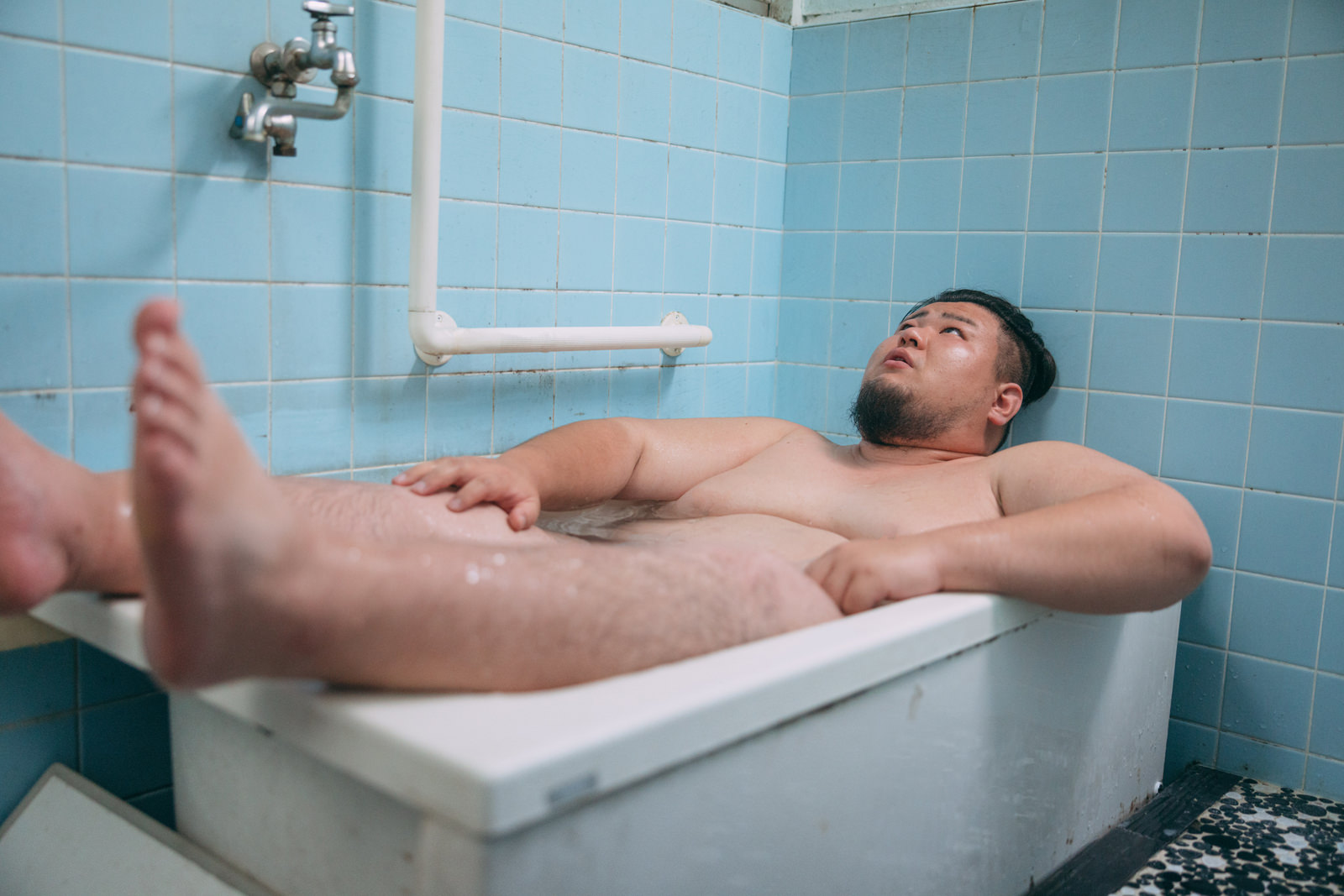 「狭い湯船に入り切らないデブ | フリー素材のぱくたそ」の写真［モデル：ノリックス］
