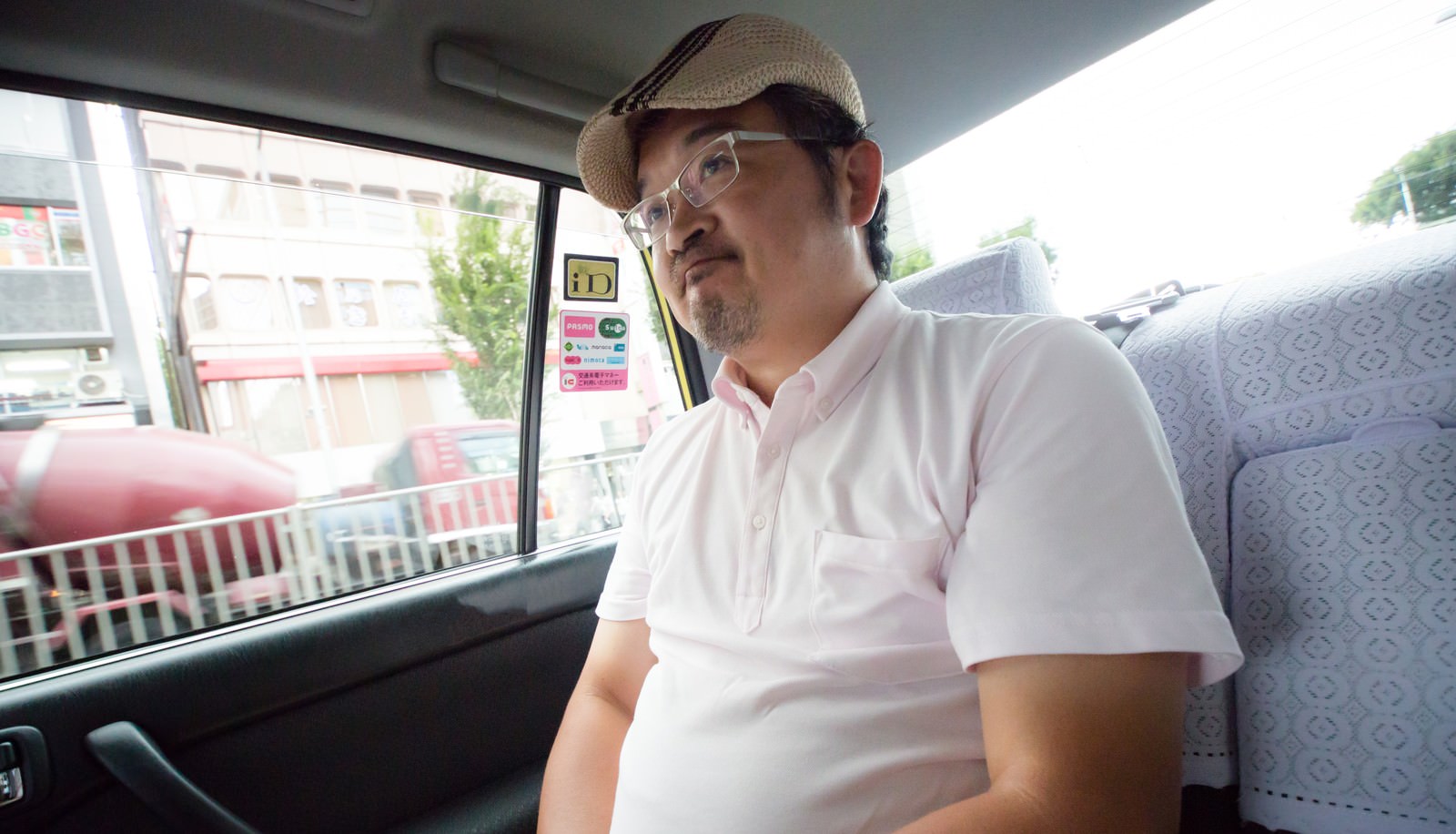 タクシーの運転手に丸くなったと言われて苦笑いをするハンチング帽の男性の写真を無料ダウンロード フリー素材 ぱくたそ