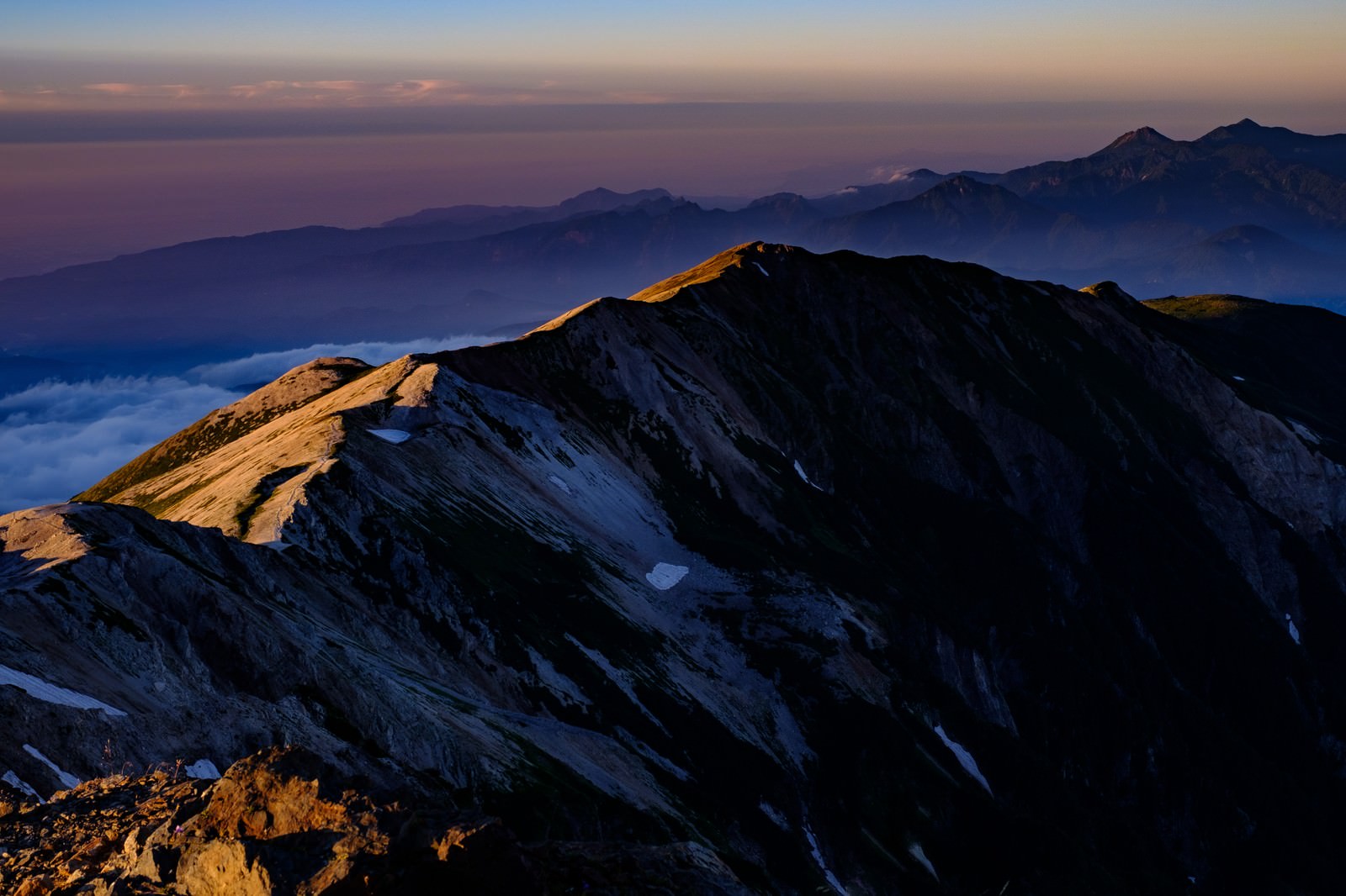 「白馬岳山頂から望む夕日に染まる稜線 | フリー素材のぱくたそ」の写真