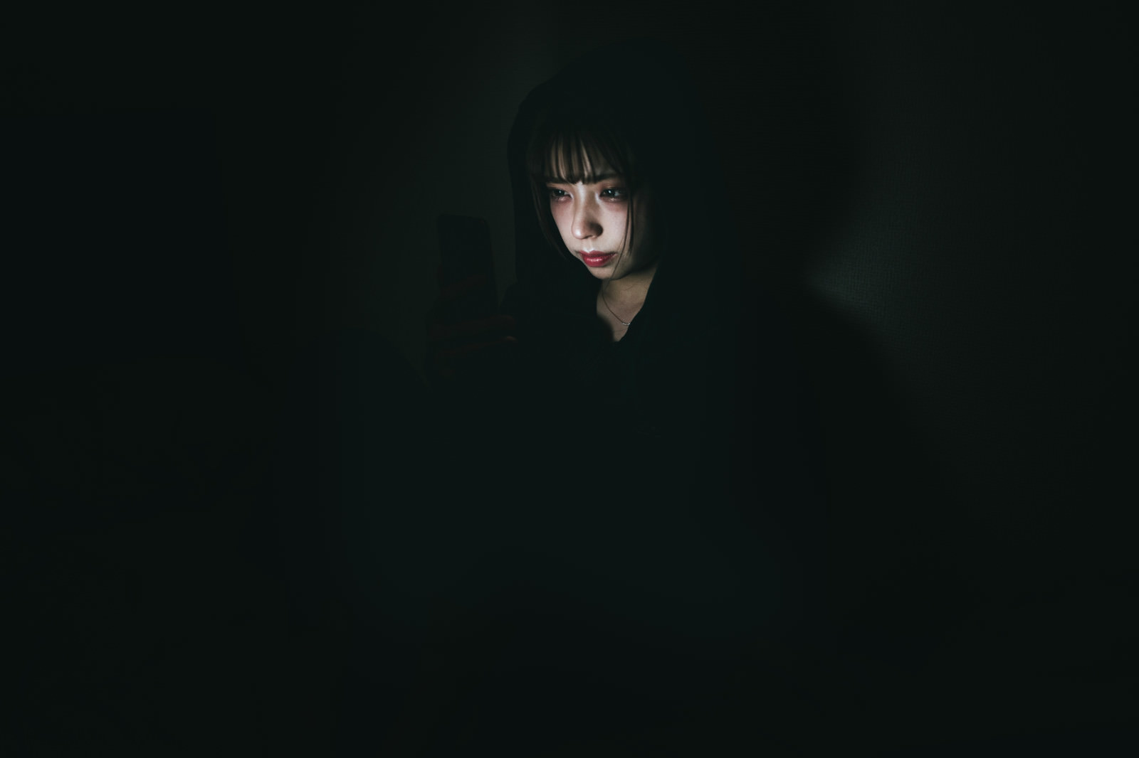 「スマホ中毒に陥る女性の様子 | フリー素材のぱくたそ」の写真［モデル：高尾実生］