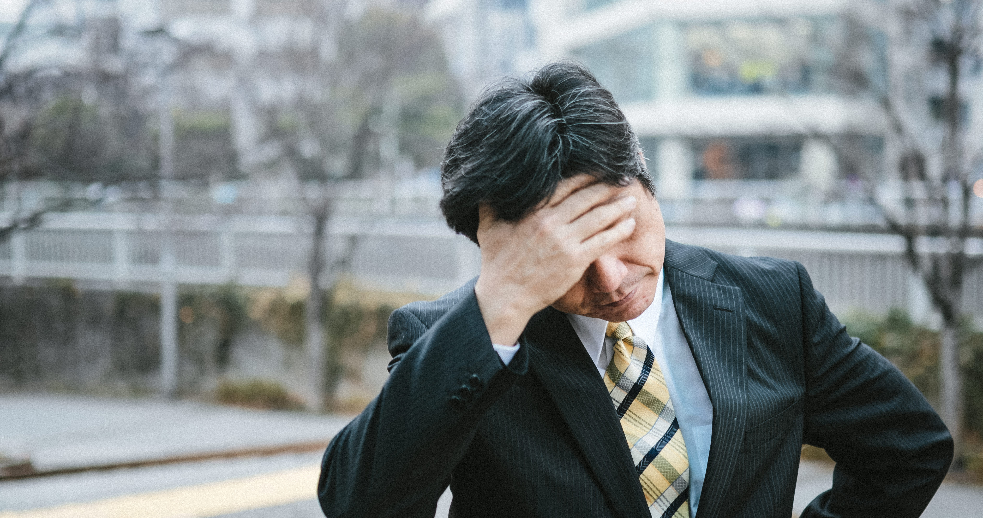 頭を抱える中年上司- フリー素材 ぱくたそ