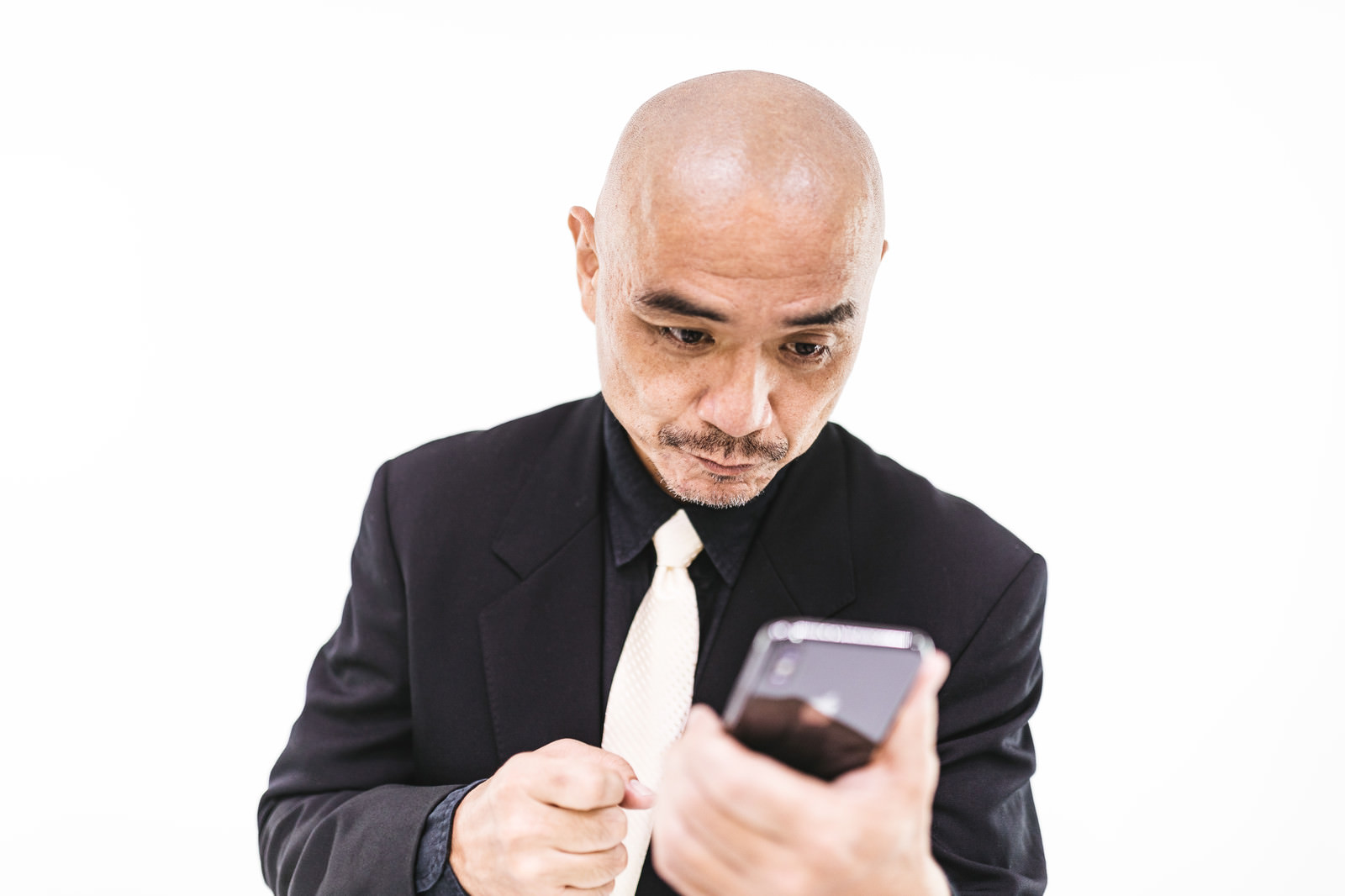 何度もスマホを見返してしまう坊主中年の写真素材 ぱくたそ