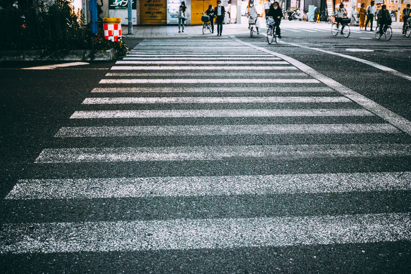 「横断歩道の先で信号待ちする人」の写真