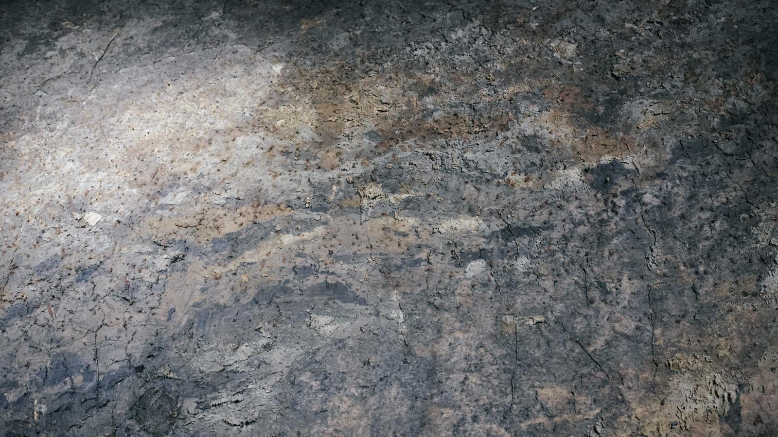 「黄土色や灰色など様々な色が混じった壁（テクスチャー） | フリー素材のぱくたそ」の写真