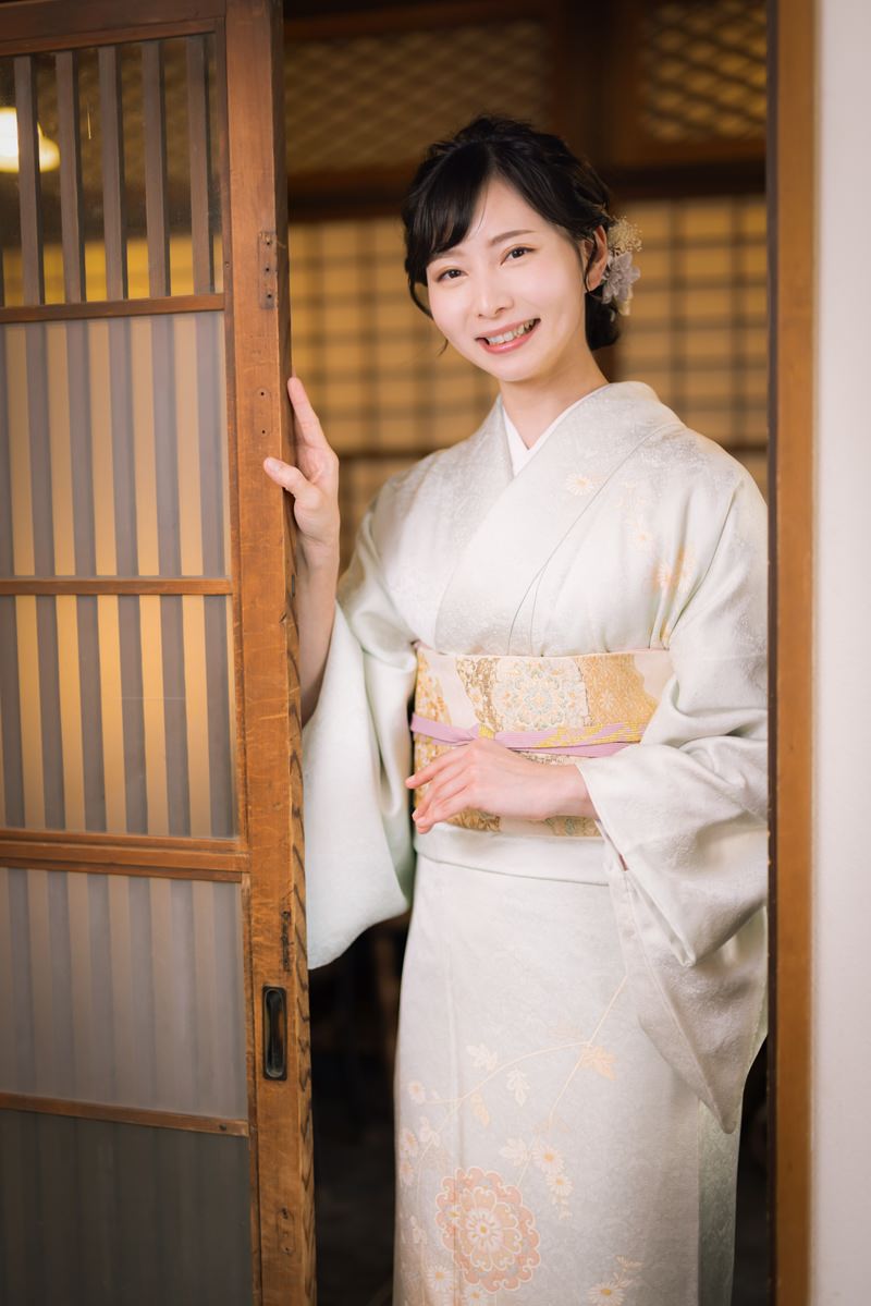 「玄関を開けてお出迎えする女将」の写真［モデル：yumiko］