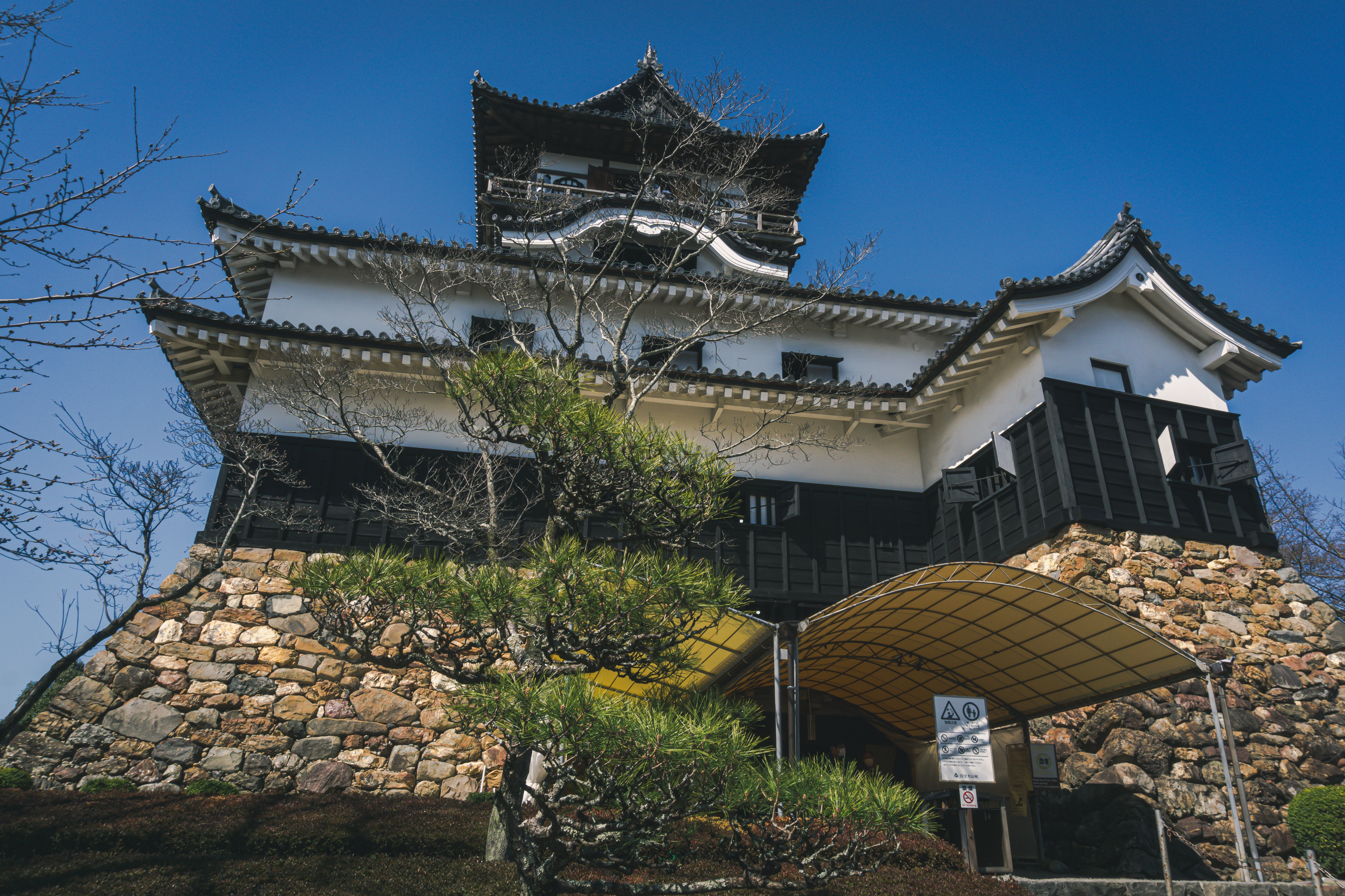 天守閣の地下二階にあたる石垣に作られた出入口にあるテントと 青空に堂々とそびえる天守閣の無料の写真素材 フリー素材 をダウンロード ぱくたそ